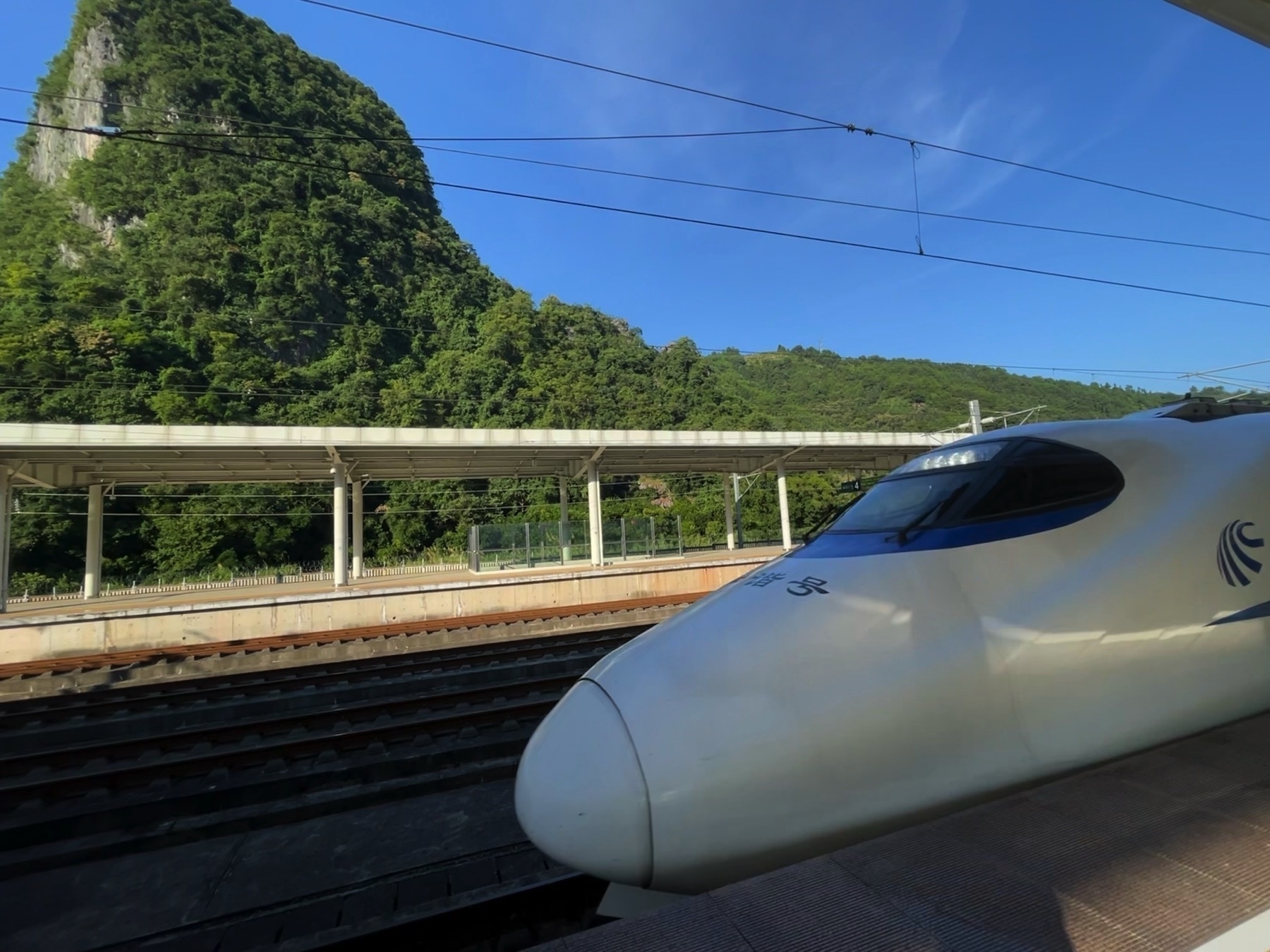 Front of a Chinese high speed train with a mountain in the background