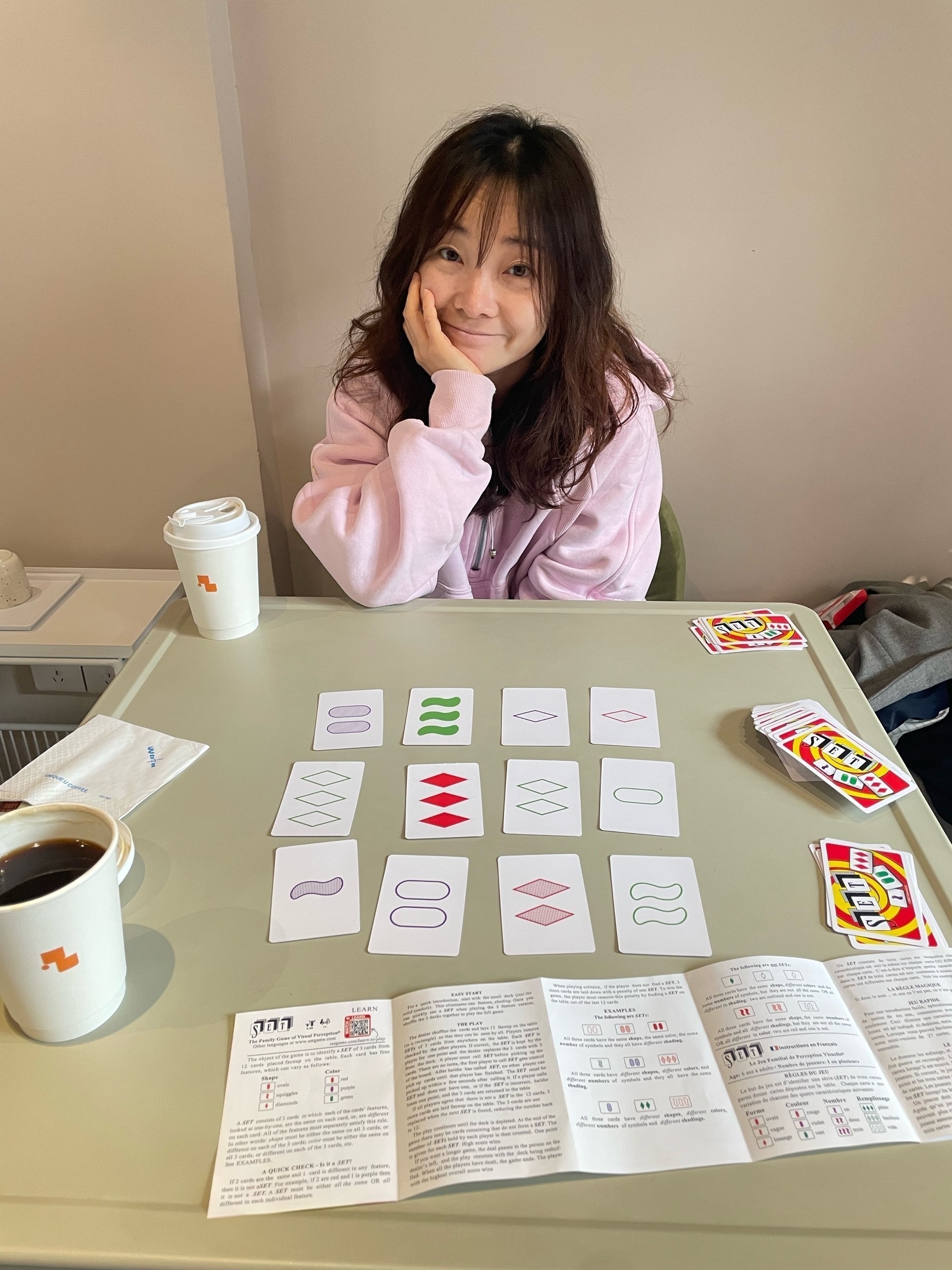 Lady smiling sat behind a table with cards on