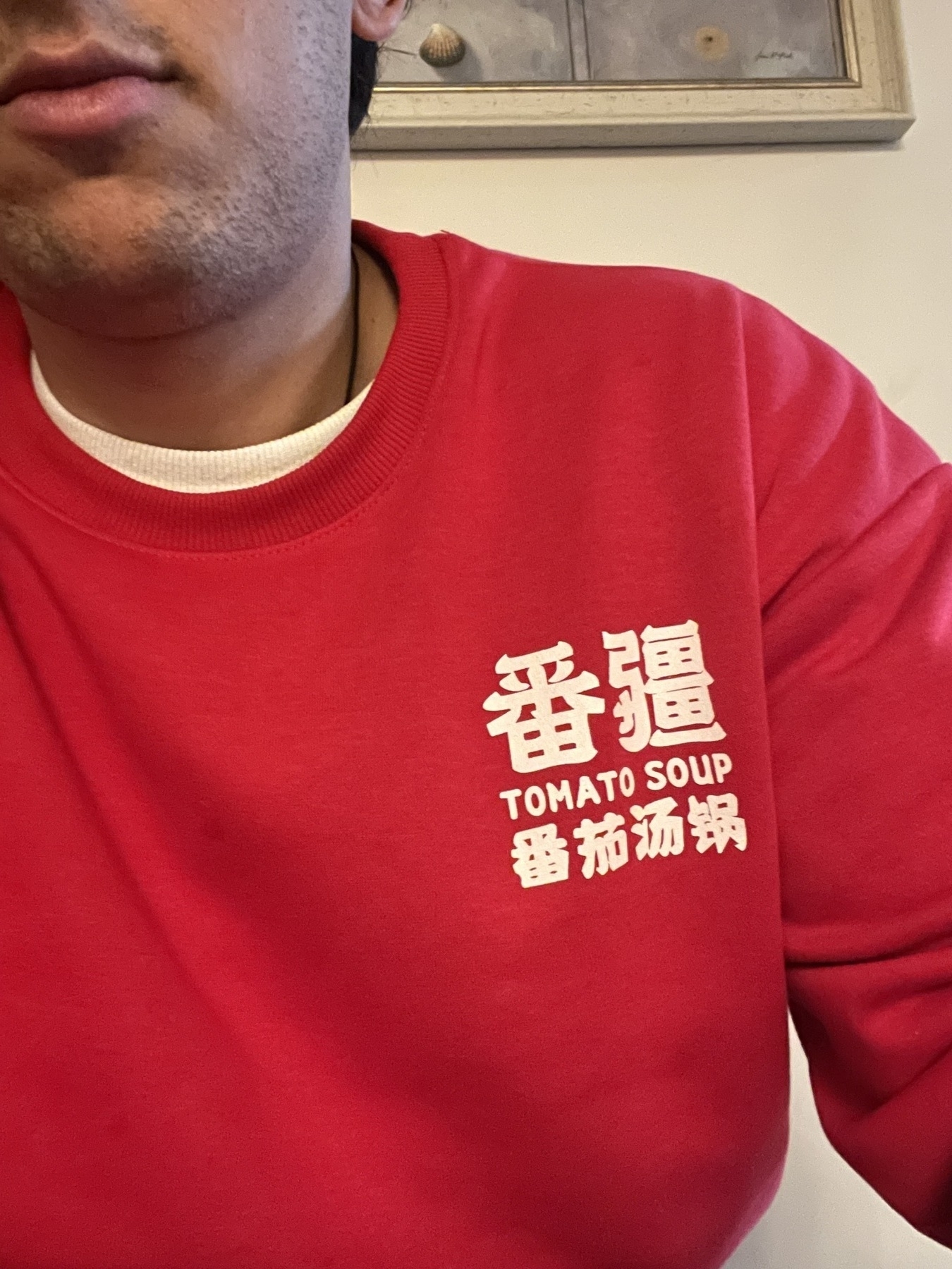 man in a red jumper with Chinese characters and the word tomato soup
