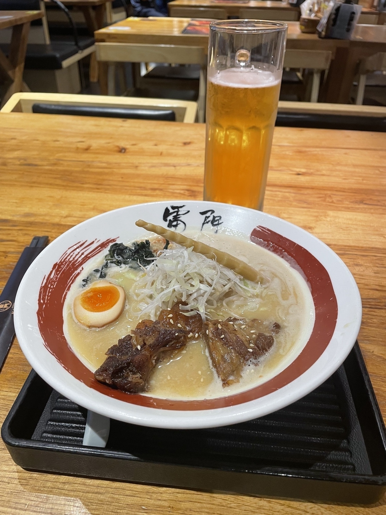 bowl of ramen with a beer