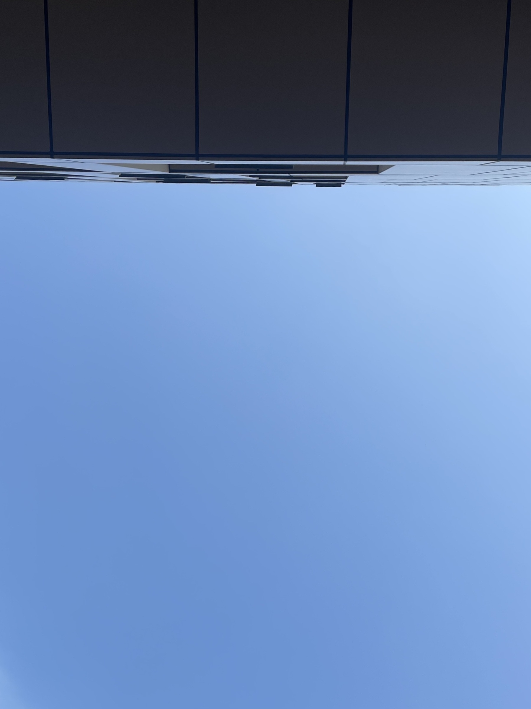 Looking up at the sky, partially framed by the edge of a modern building.