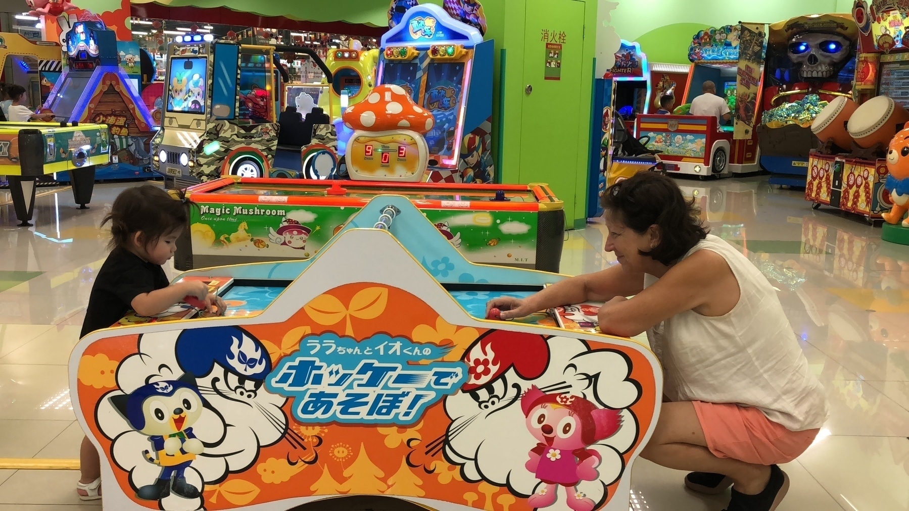 girl and lady playing air hockey