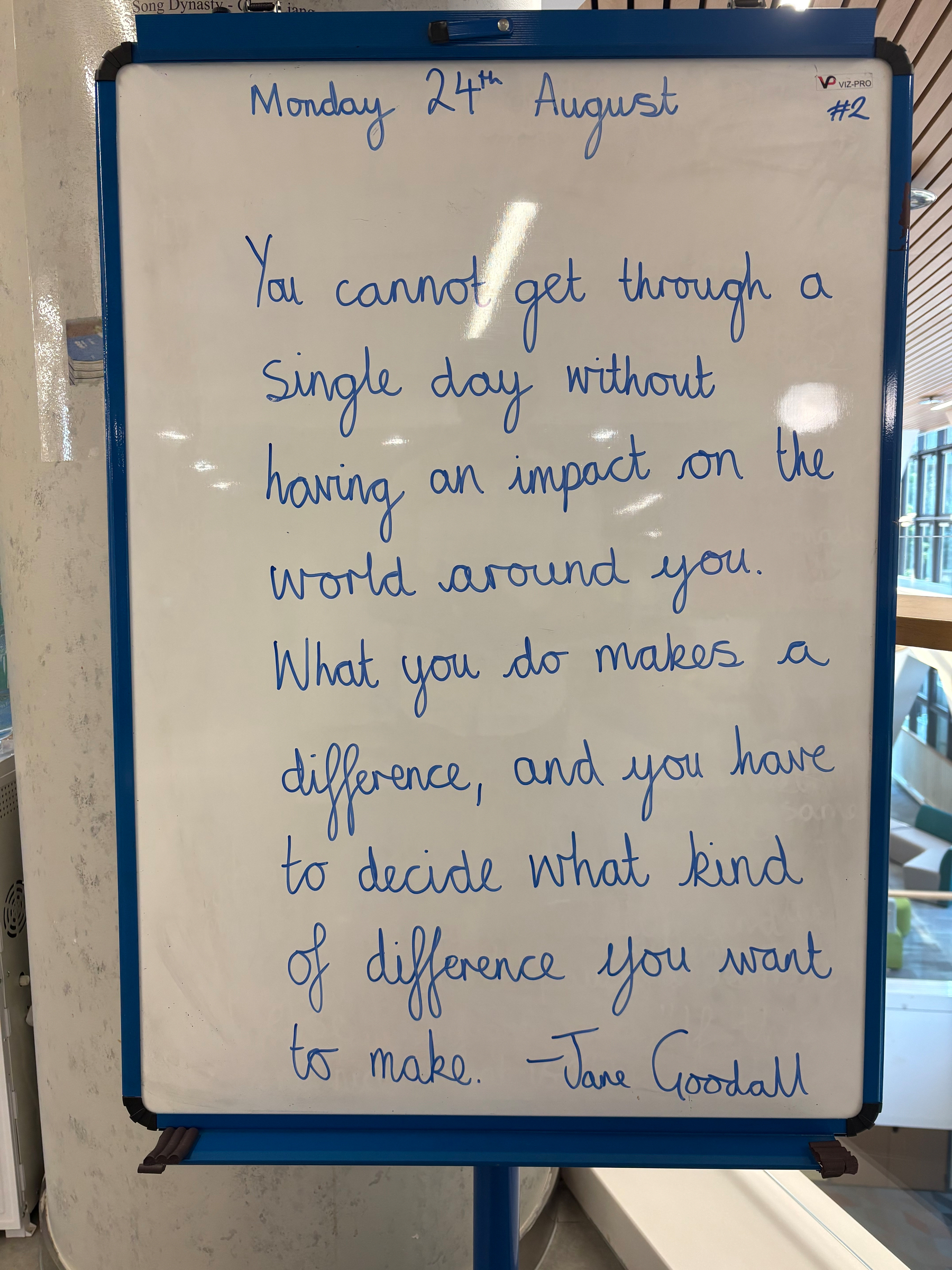 A motivational quote by Jane Goodall written on a whiteboard dated Monday, 24th August, emphasizes making a positive difference in the world every day.