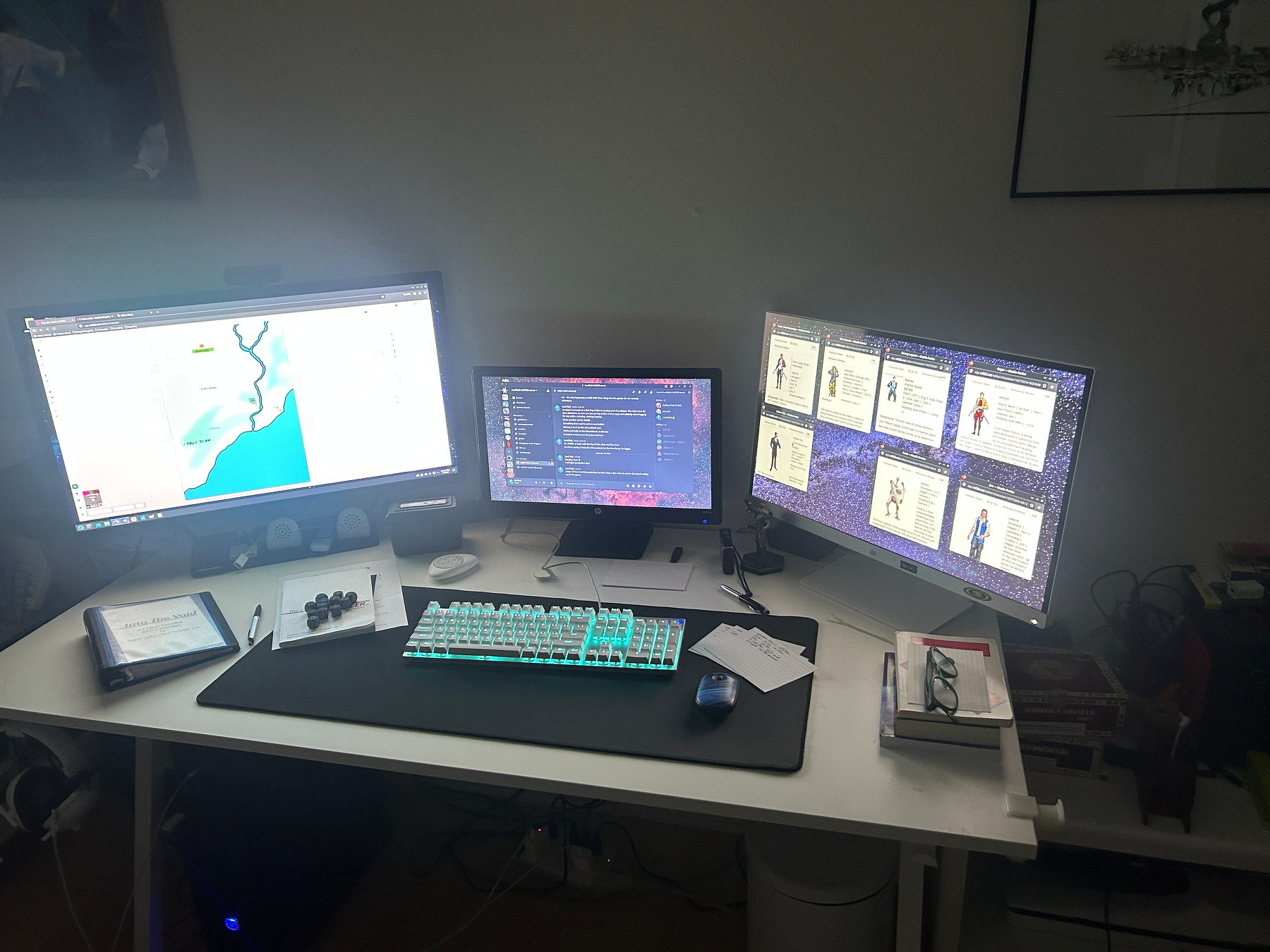 computer setup with 3 monitors and blue glowing keyboard
