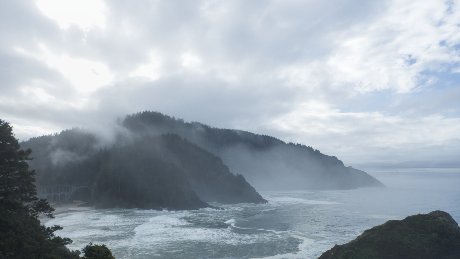 coastal mountains with bridge and fog