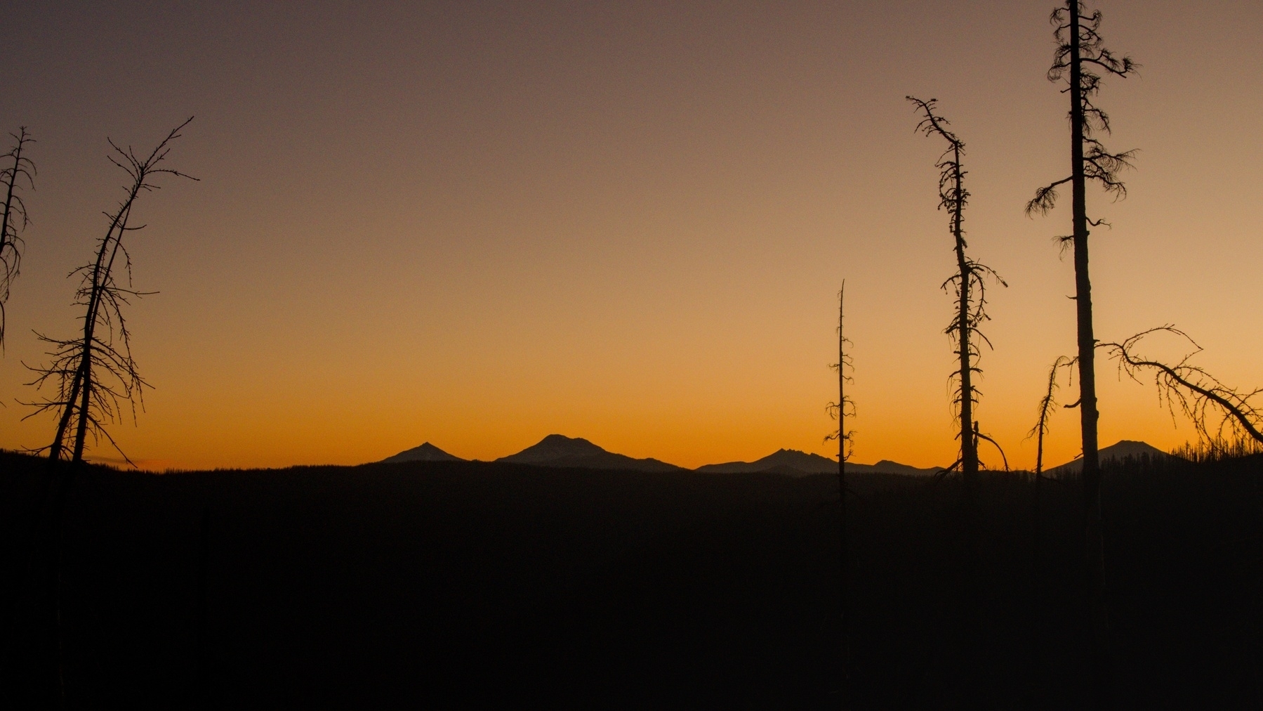 mountains silhouetted against orange sky