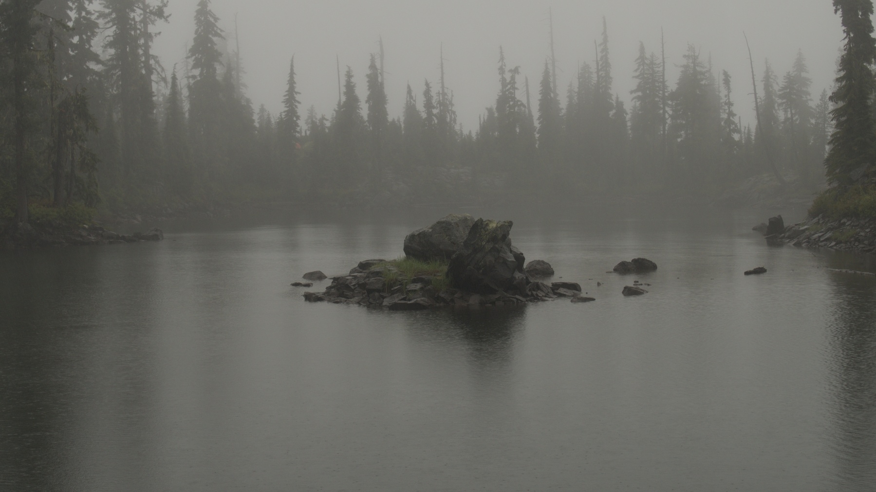 rock island in a mist-shrouded lake