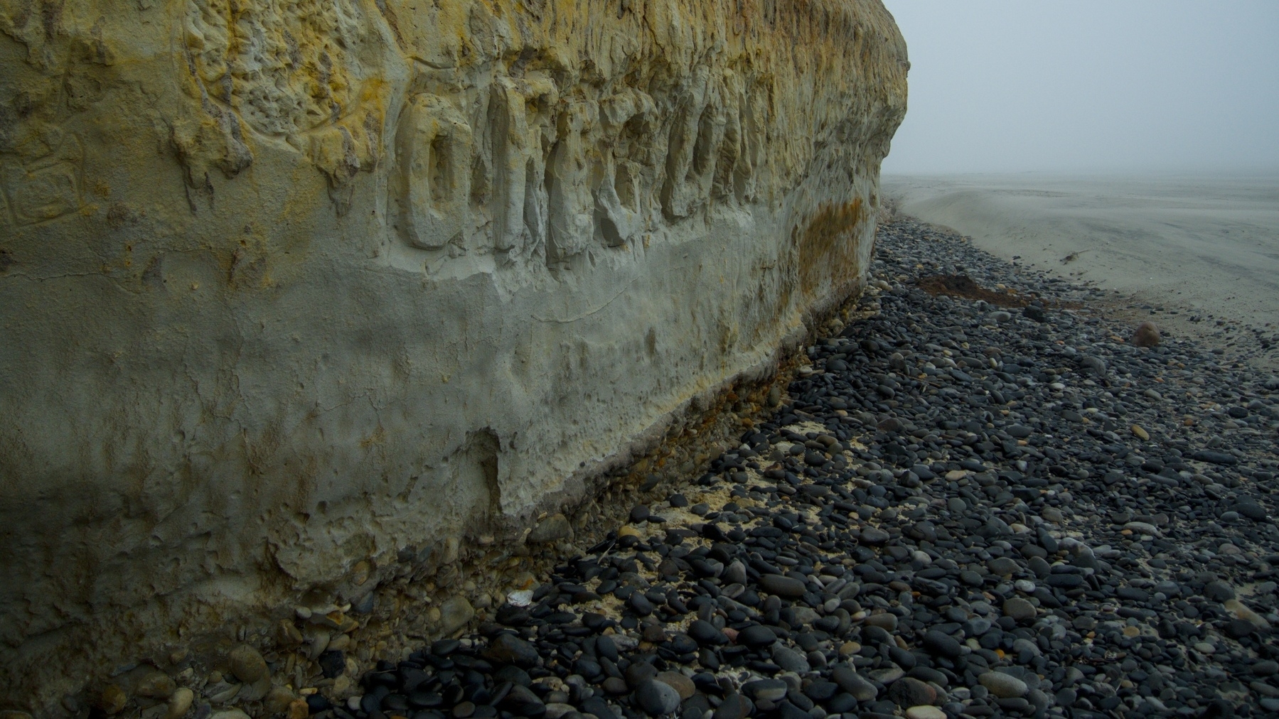 graffiti carved in a sand cliff