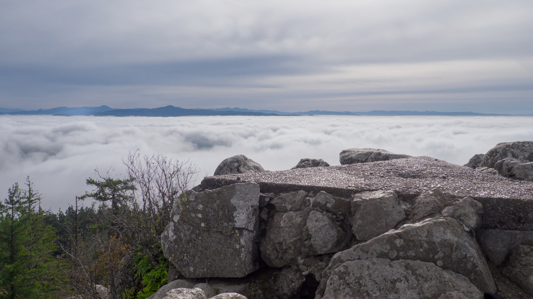 old concrete antenna mount in front of a sea of clouds