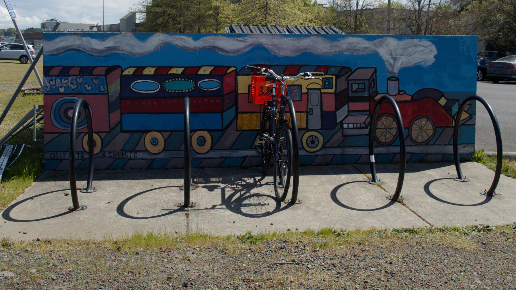 bike parked in front of a train mural