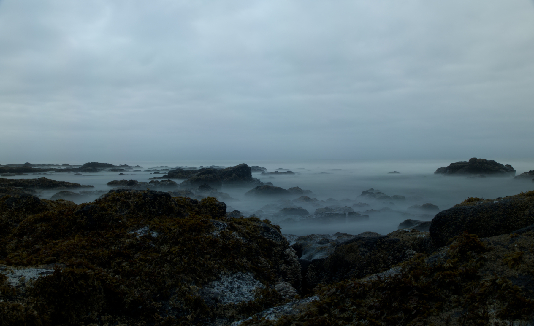 long exposure of rocks, waves, and clouds
