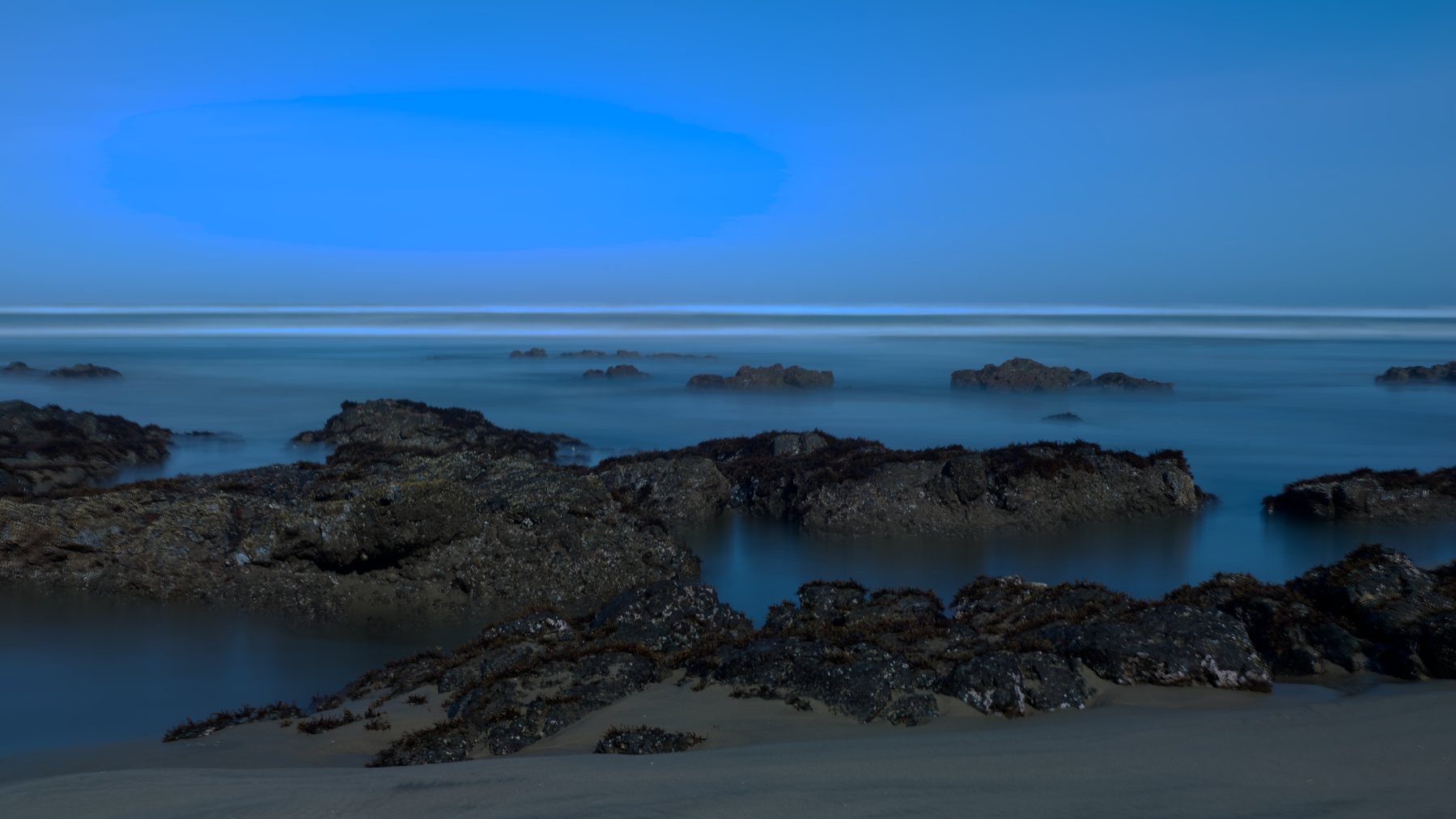long exposure of beach, rocks, and sea