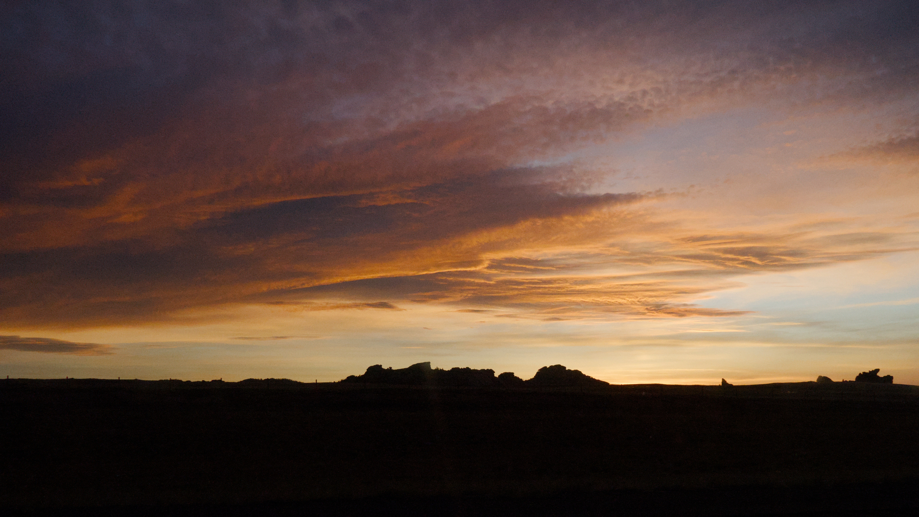 colored clouds over dark rock