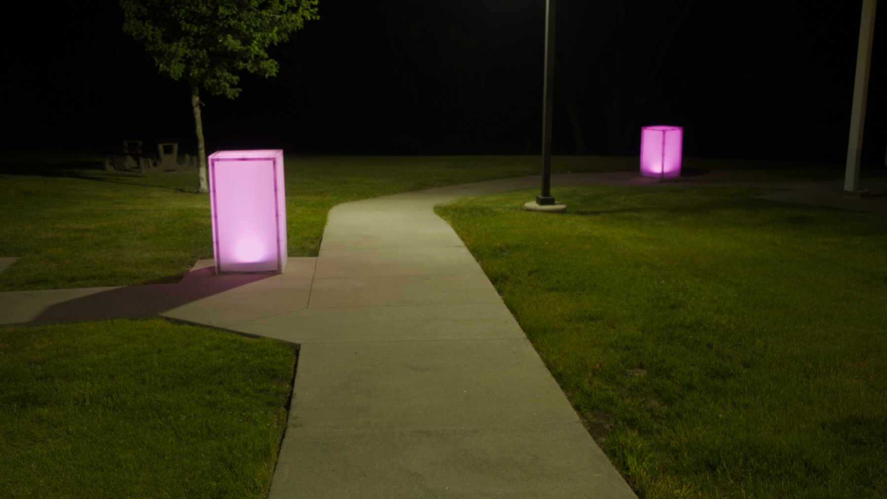 sidewalk with glowing pink boxy lights