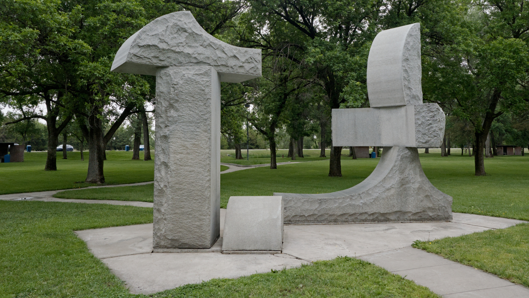 blocky sculpture surrounded by trees and grass