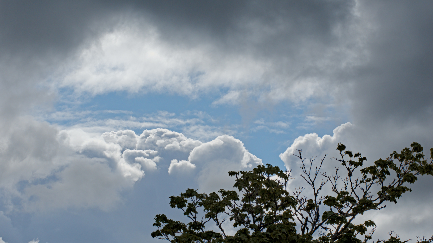 a bit of blue sky peeking through dark clouds