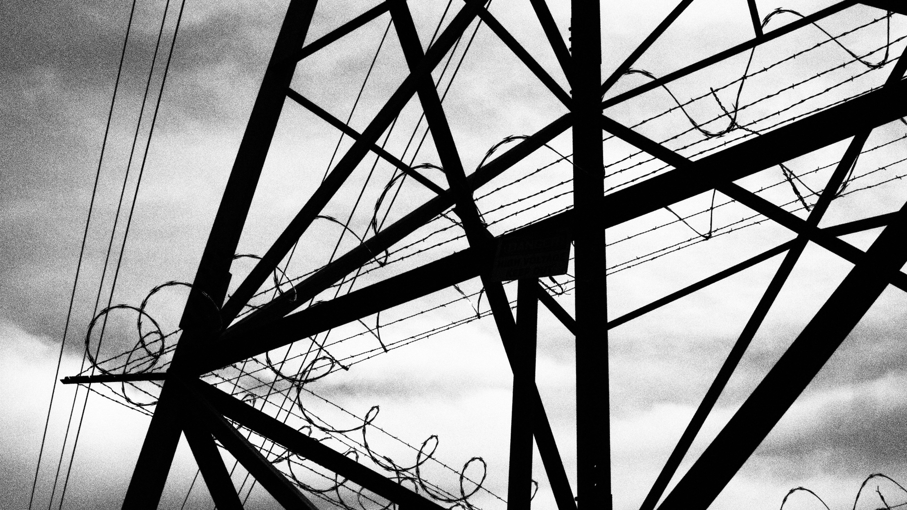 electric pylon surrounded by barbed wire
