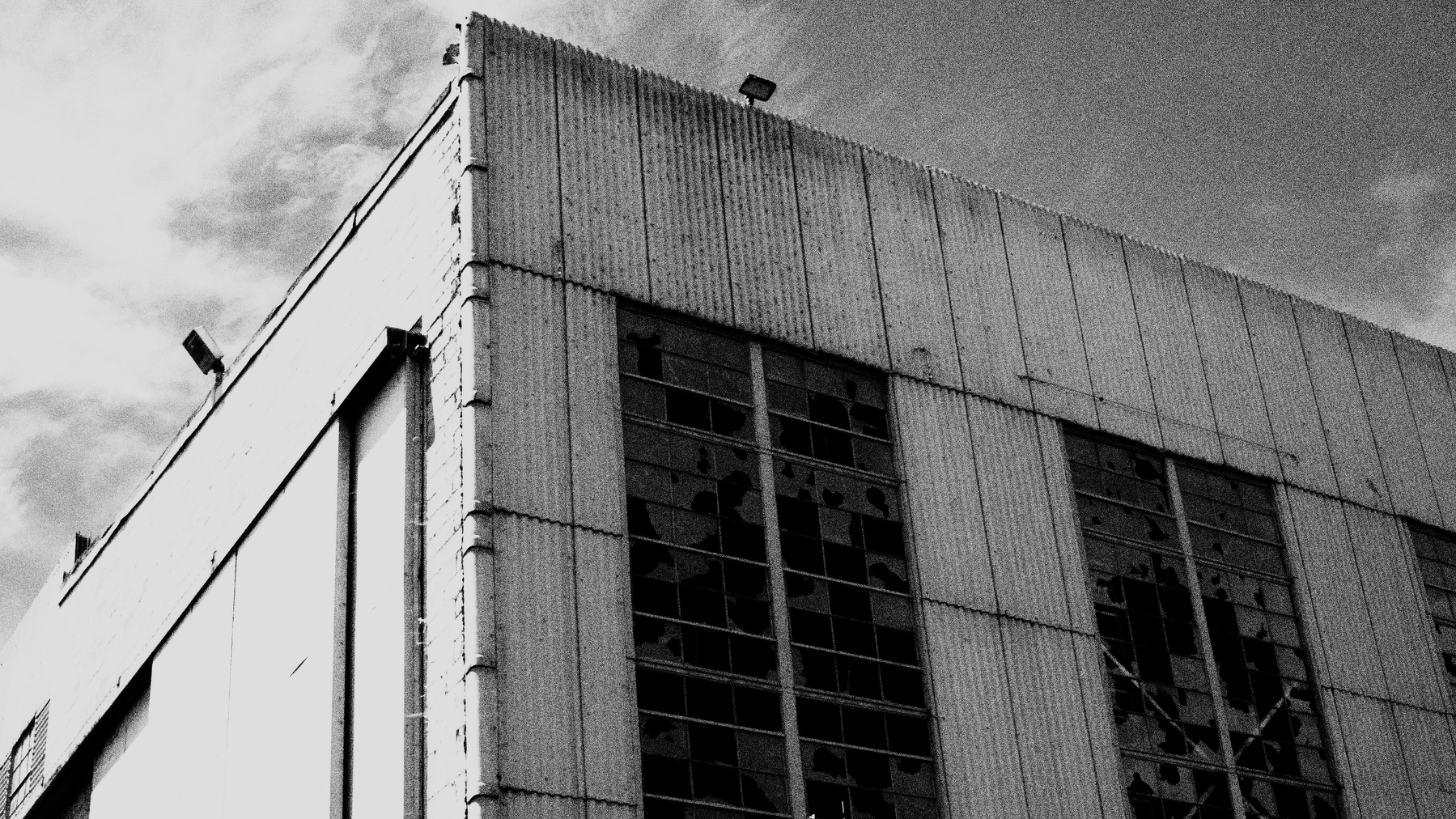 Industrial building with broken windows in black and white