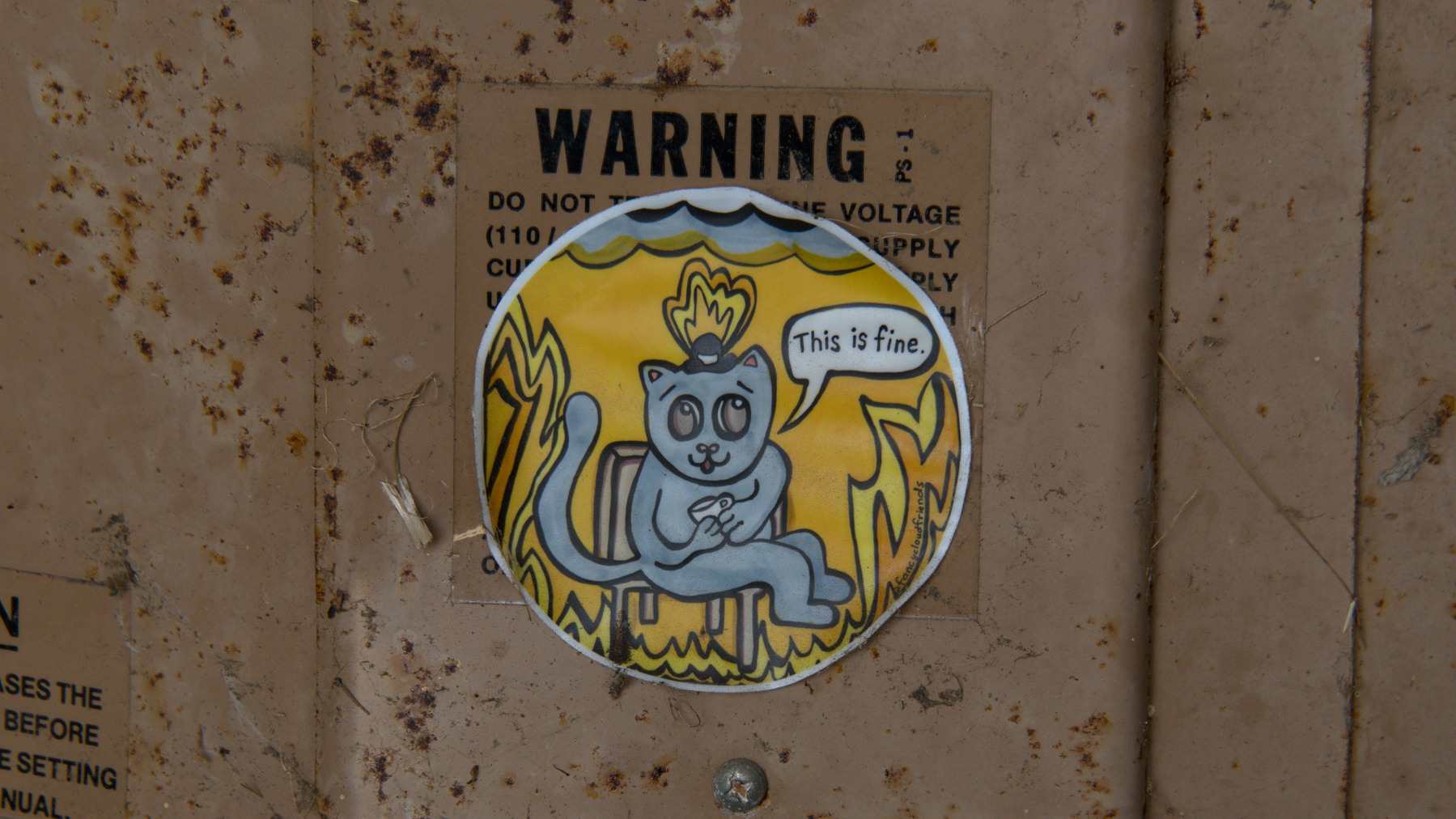 "This is fine" sticker over a warning label