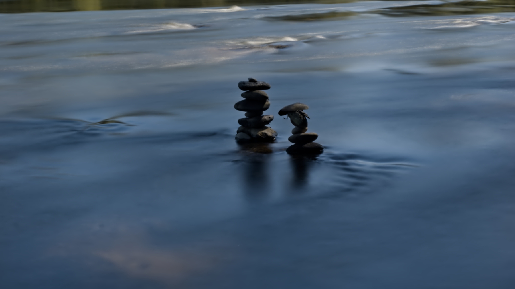 two stacks of rocks surrounded by blue water