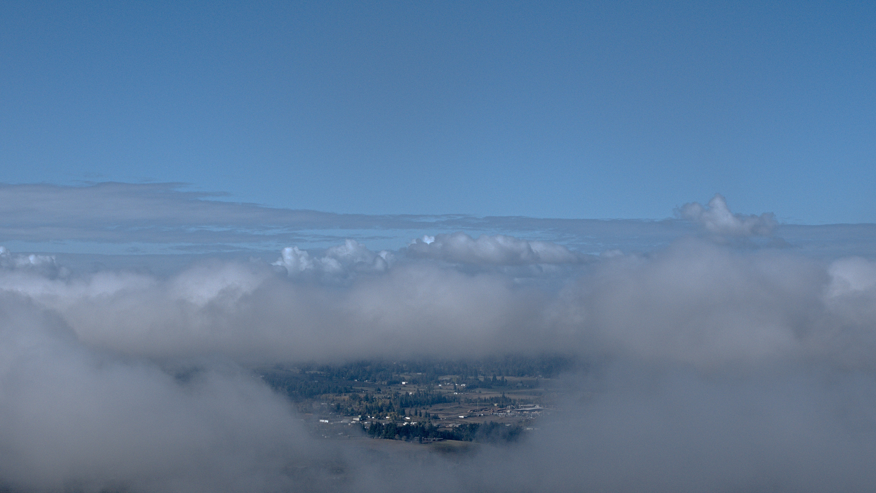 a hole in the clouds shows the land beneath