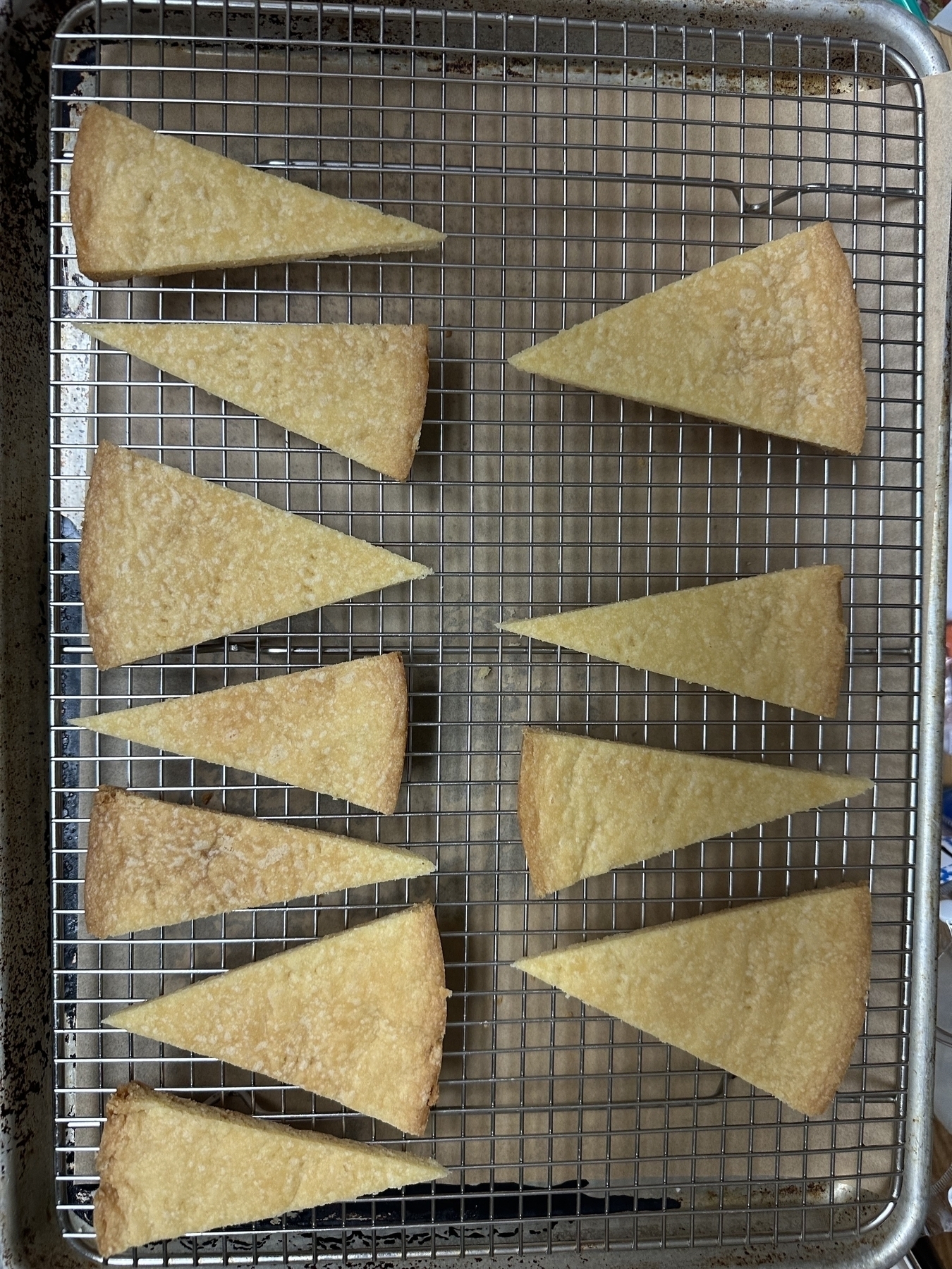 A cooling rack filled with triangular pieces of shortbread. 