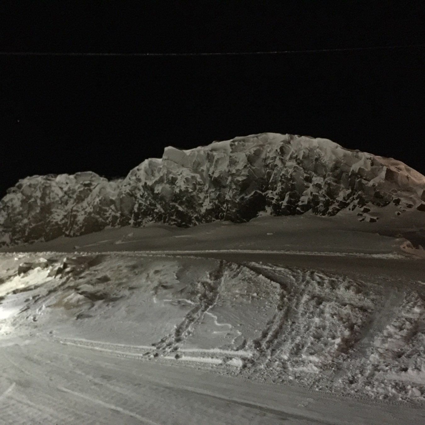 snow-covered rock monolith at night