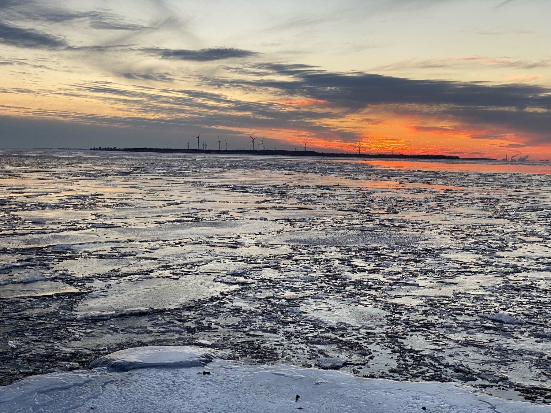 Lake with ice forming, fiery sunset