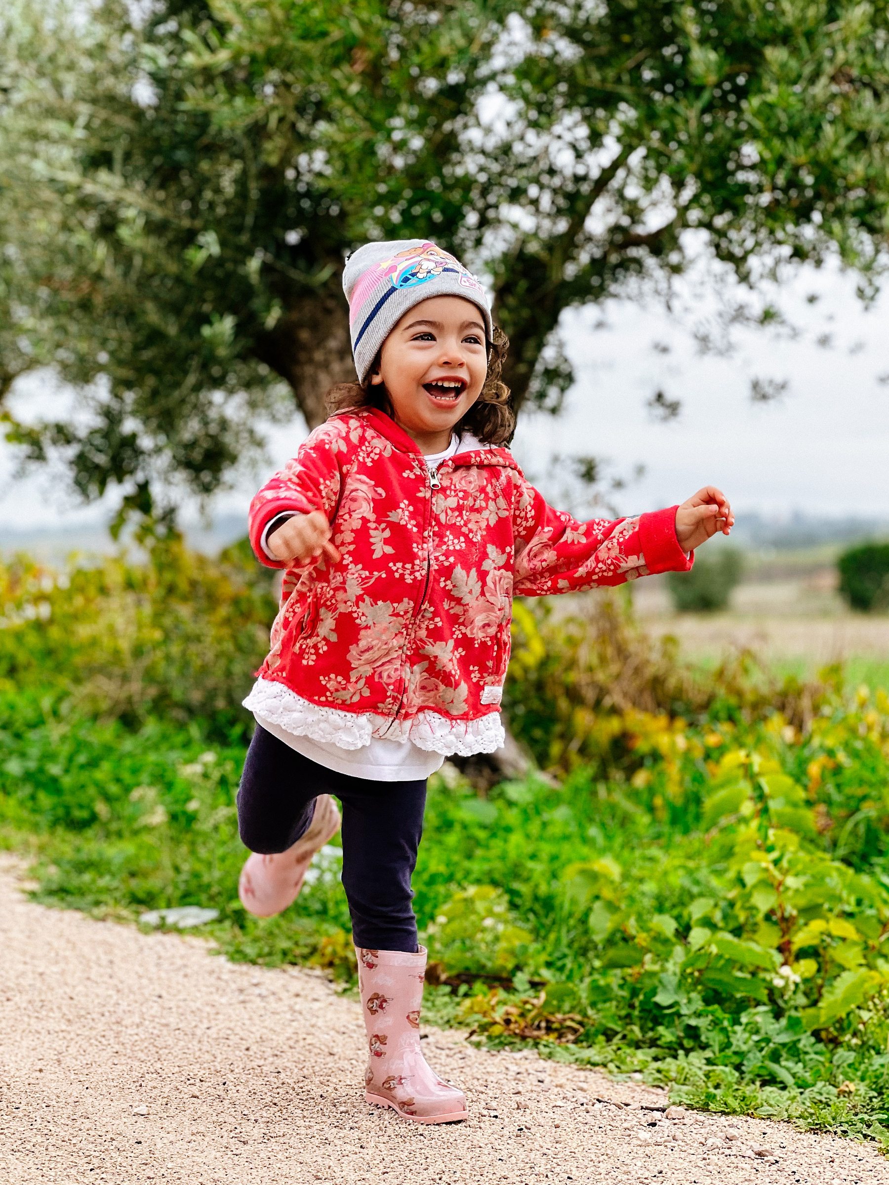 a toddler, laughing, in the field