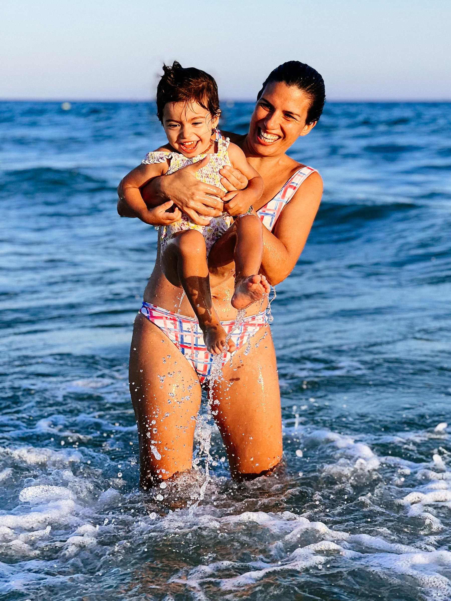 mom and toddler have fun in the sea