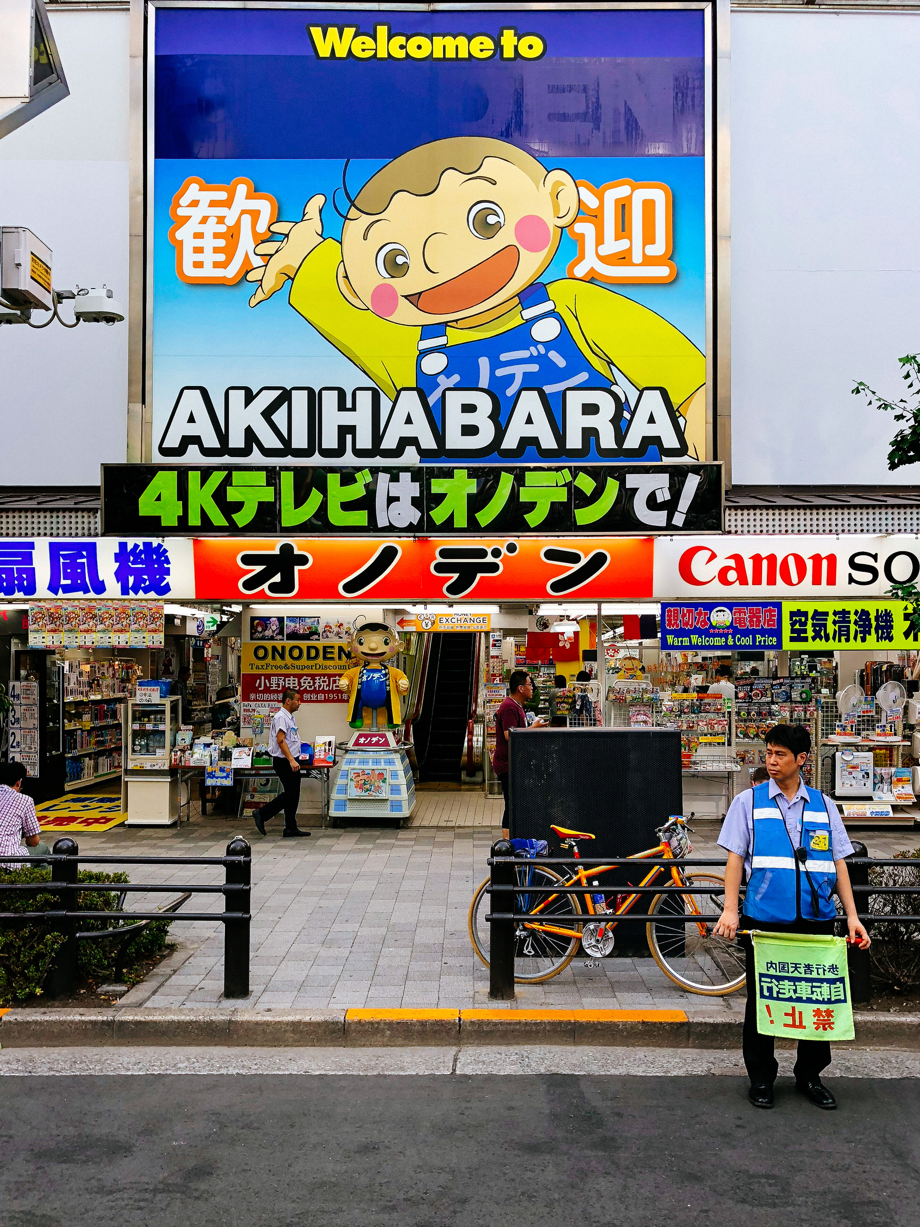 a sign saying “welcome to Akihabara” lights up the street