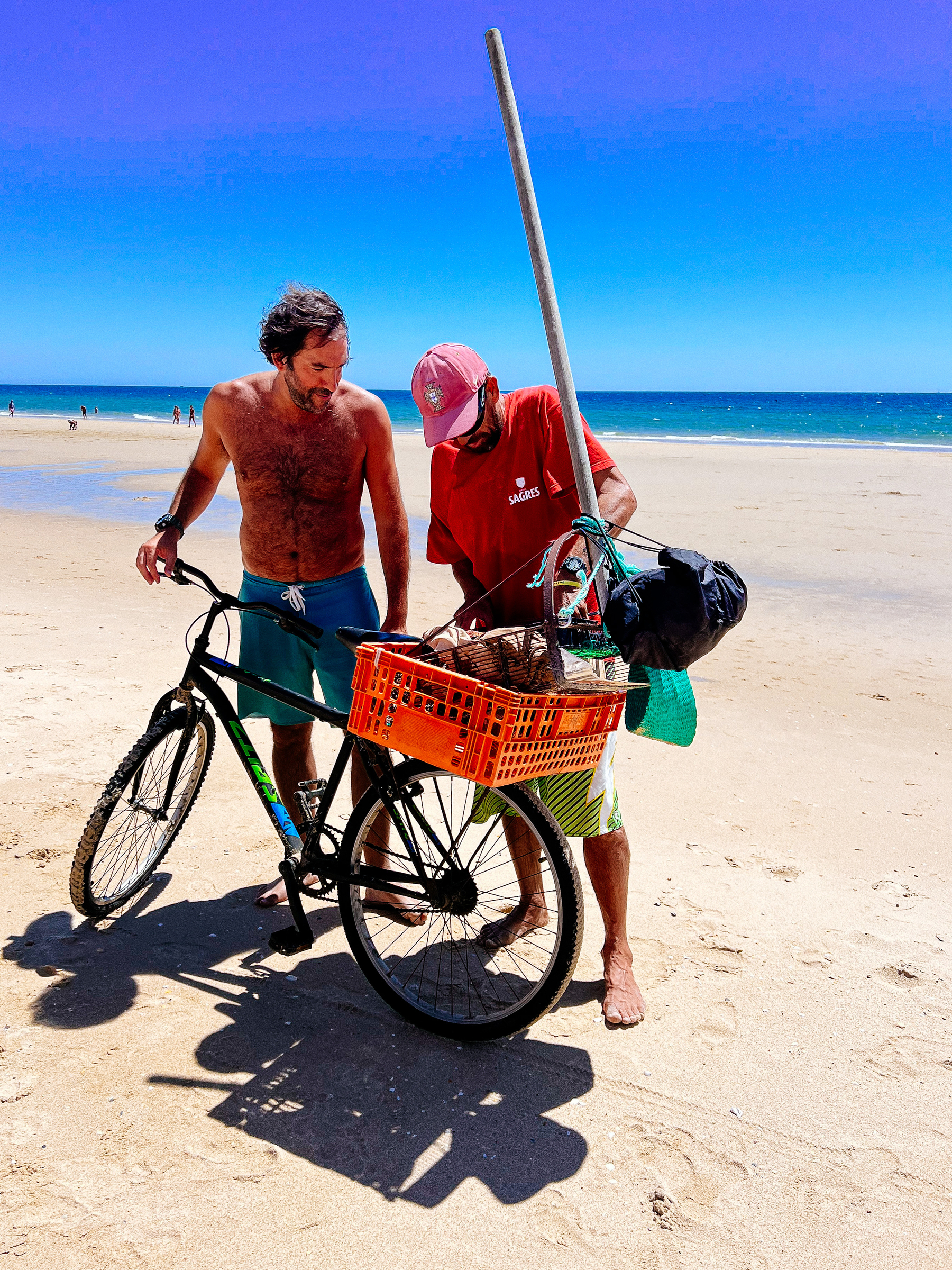 two man and a bicycle, on the beach