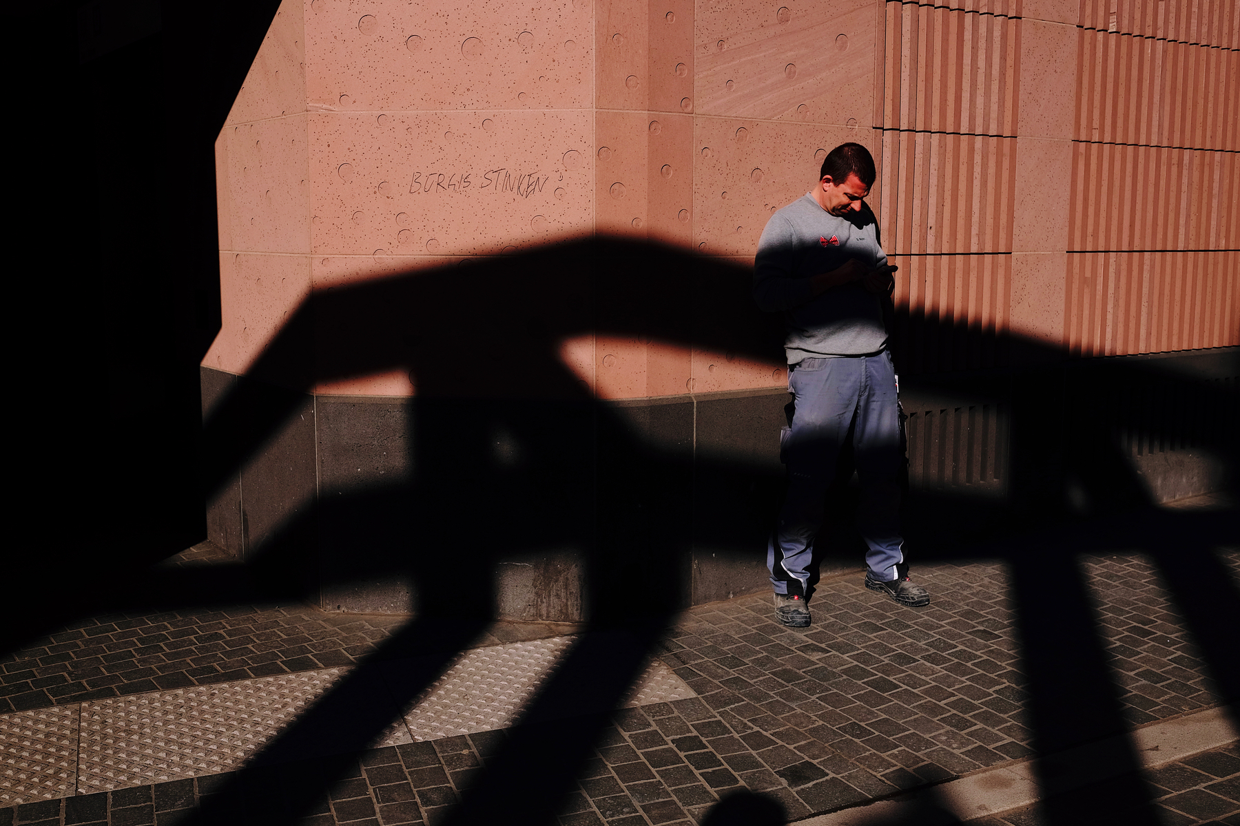 A man partially covered by web-like shadows. 