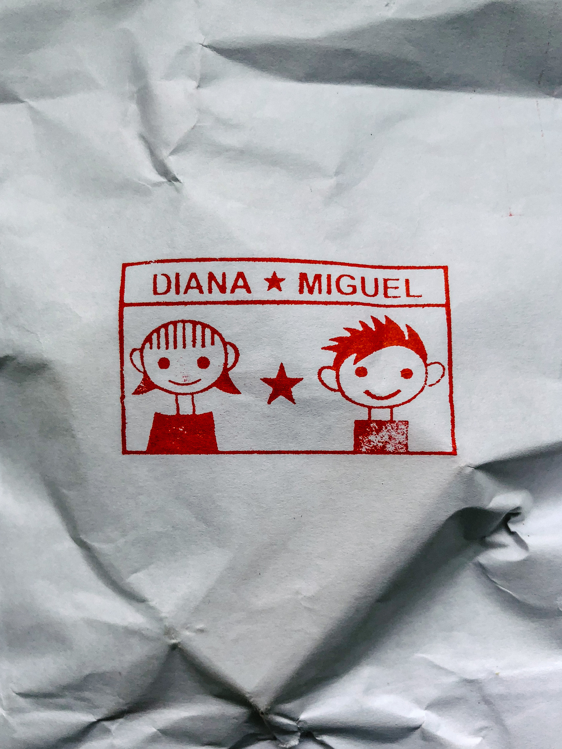 Stamped in a piece of paper, a drawing of a girl and a boy, with a star in the middle.  Above them “Diana star Miguel”