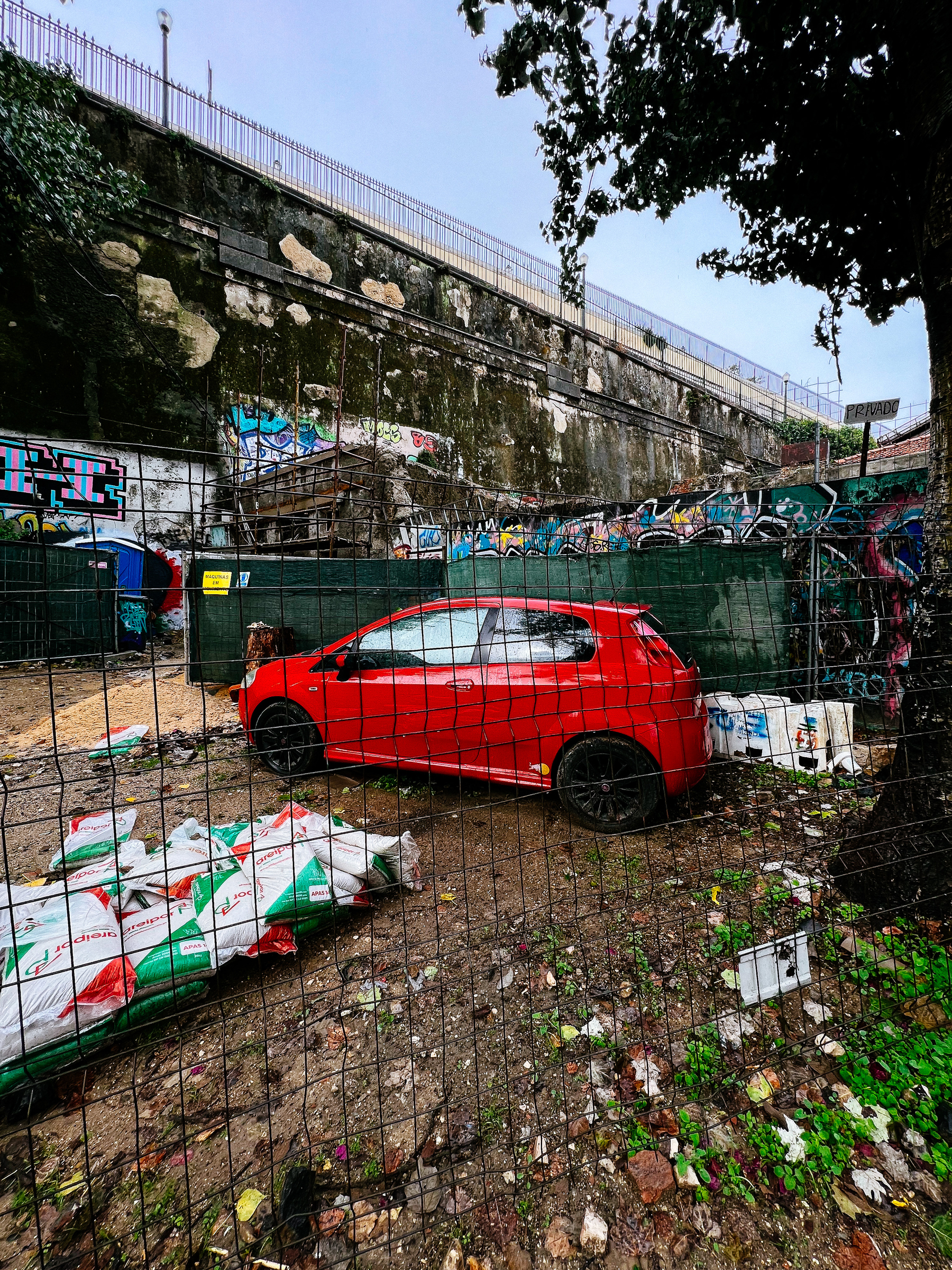 a red car sitting in a vacant lot