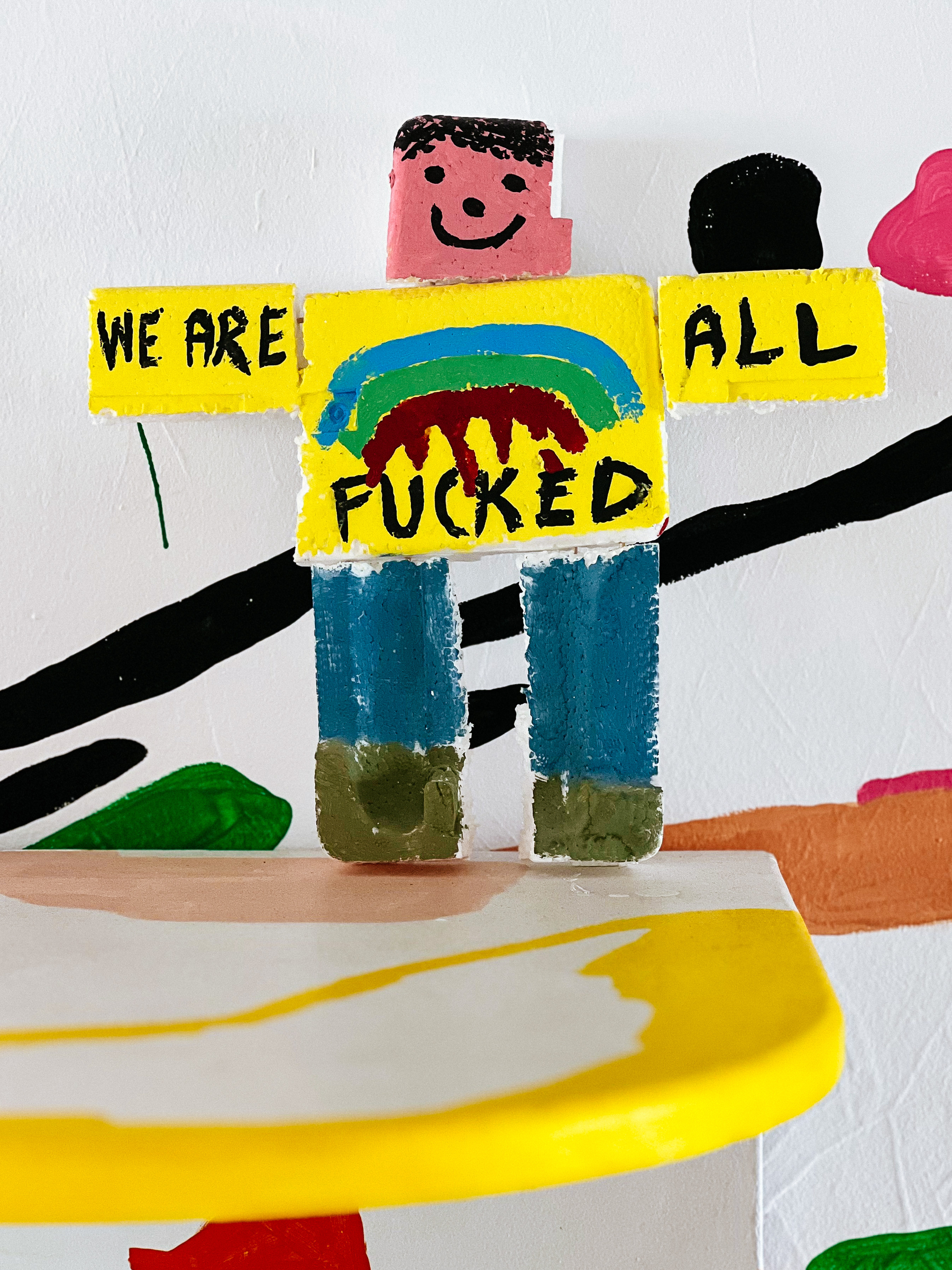 A strange doll with the words “we are all fucked” written on it