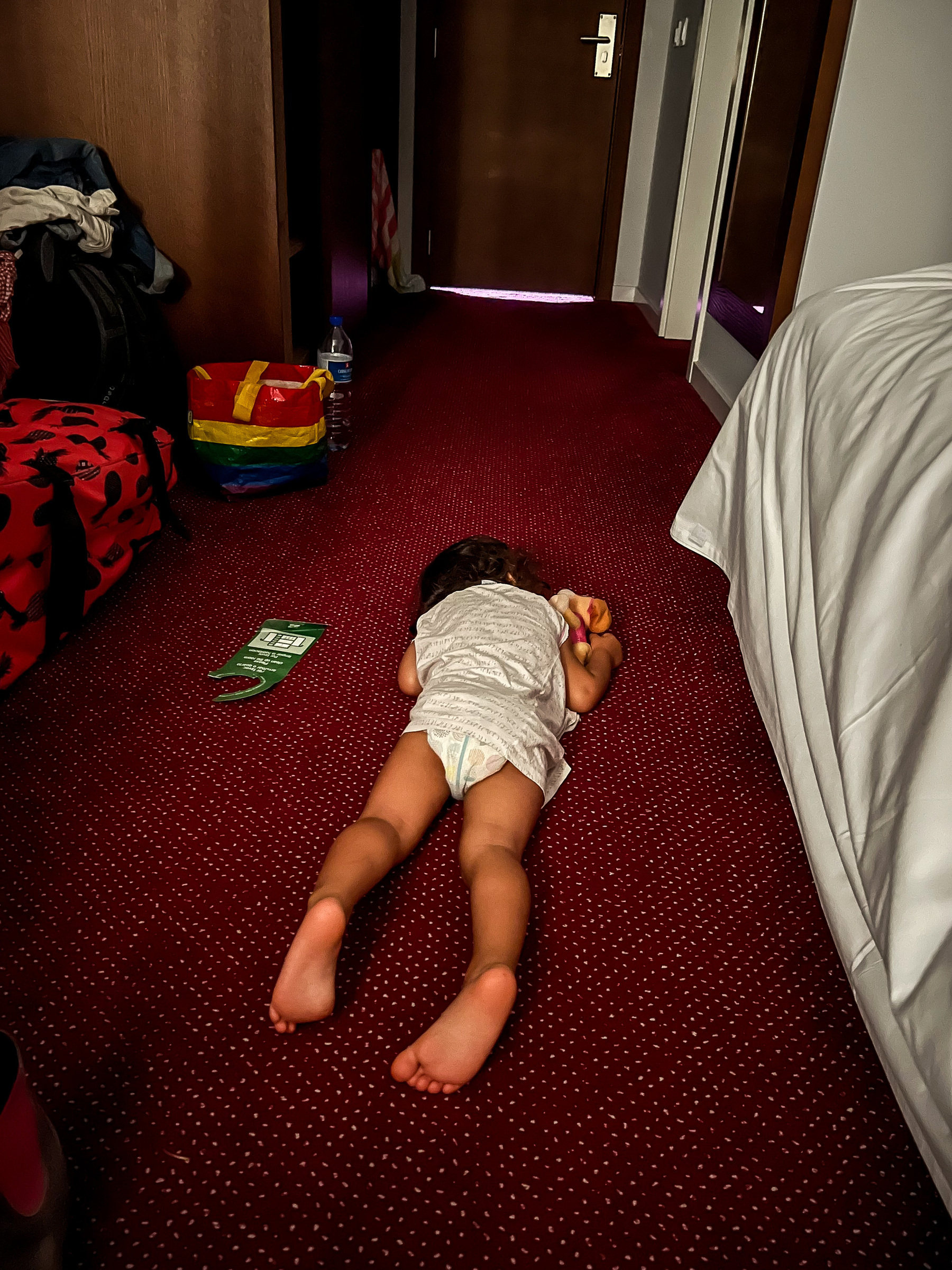 Toddler sleeping on the hotel room’s floor