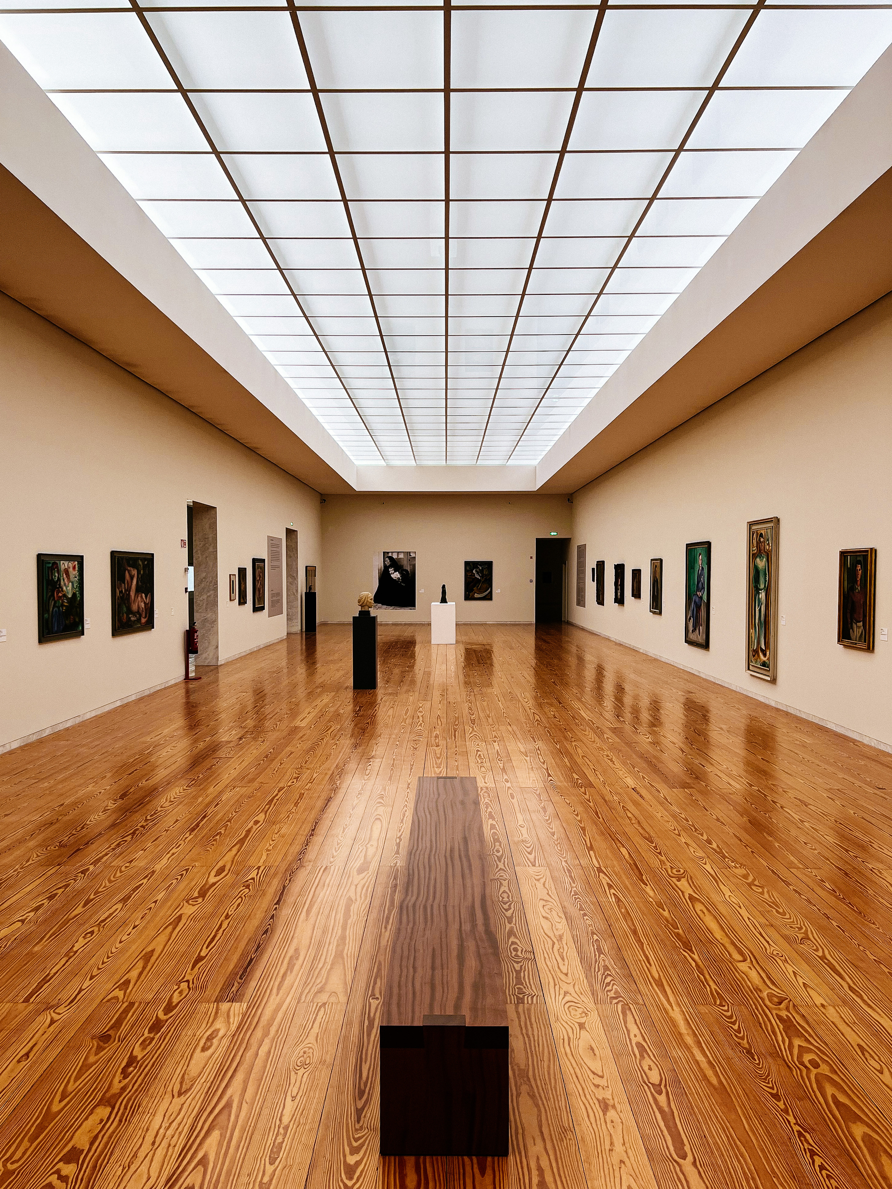 The inside of a museum. Big room, with art on the walls. 