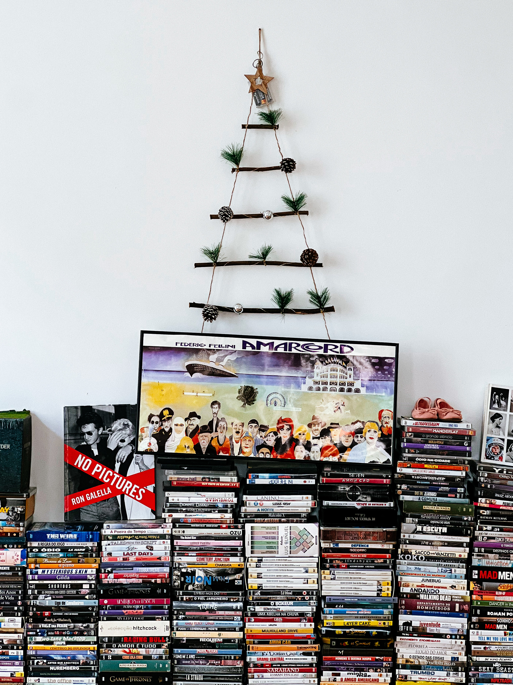 A simple Christmas tree sits on top of a pile of DVD. 
