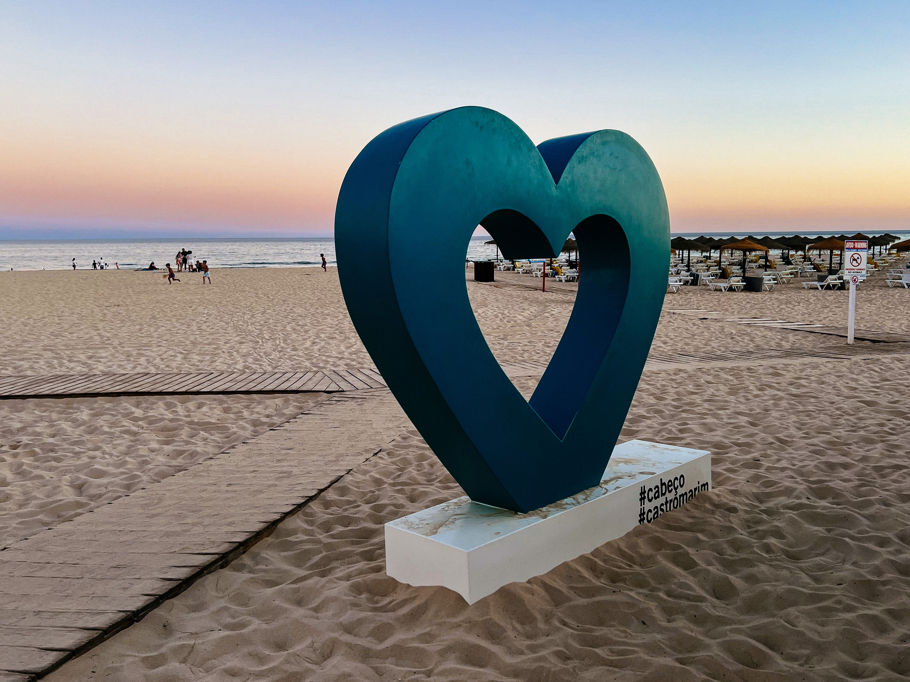 a big heart stands at the entrance to the beach