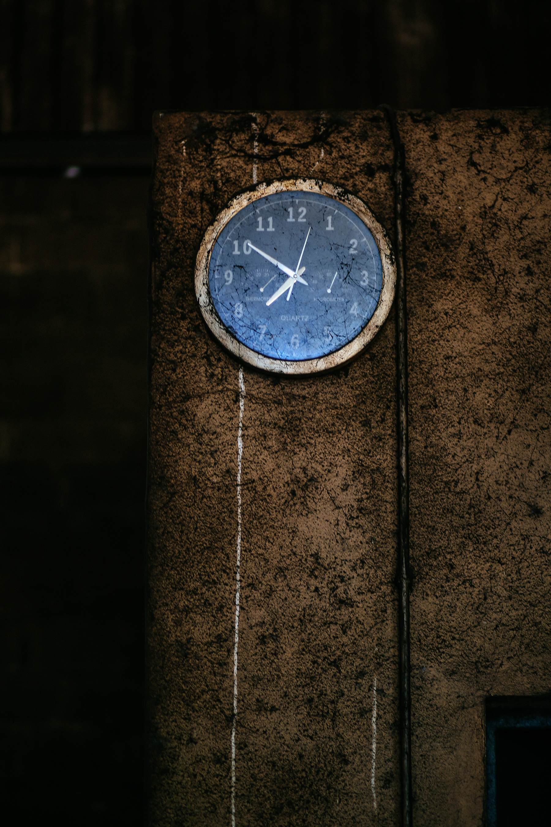 a clock on a very dirty and dark wall
