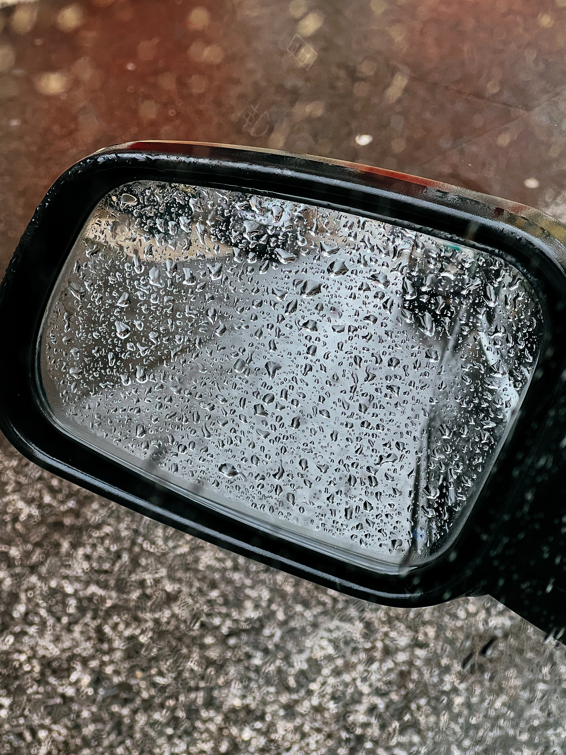 Raindrops on a car side mirror. 