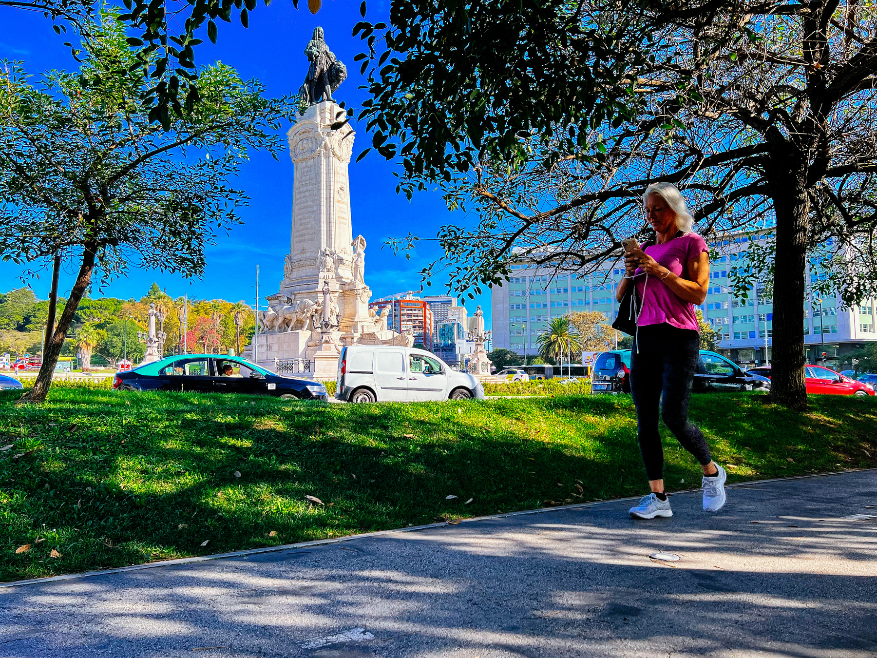 A woman walks on a bike path, close to a huge statue