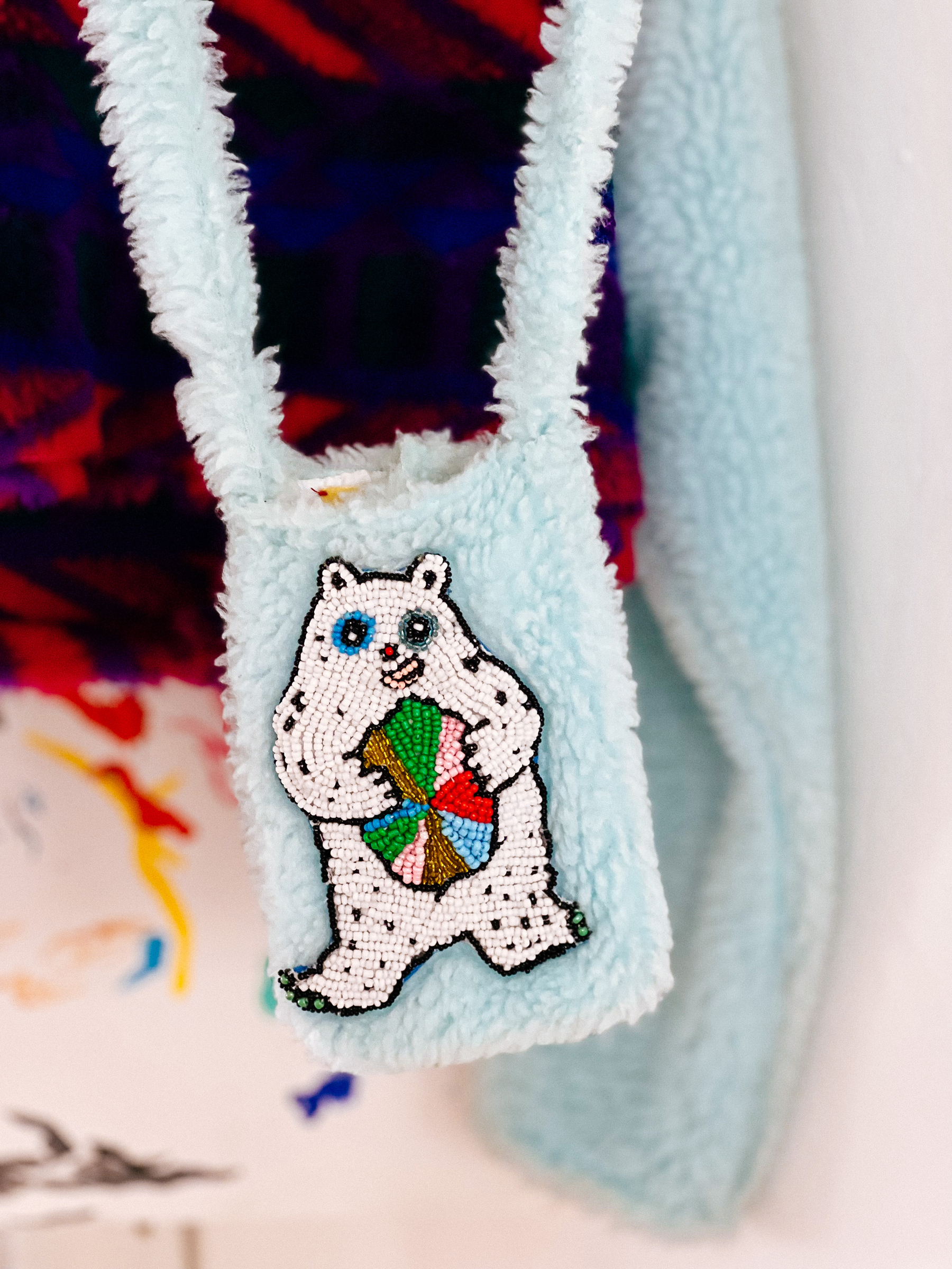 A purse with a white bear holding a colored ball
