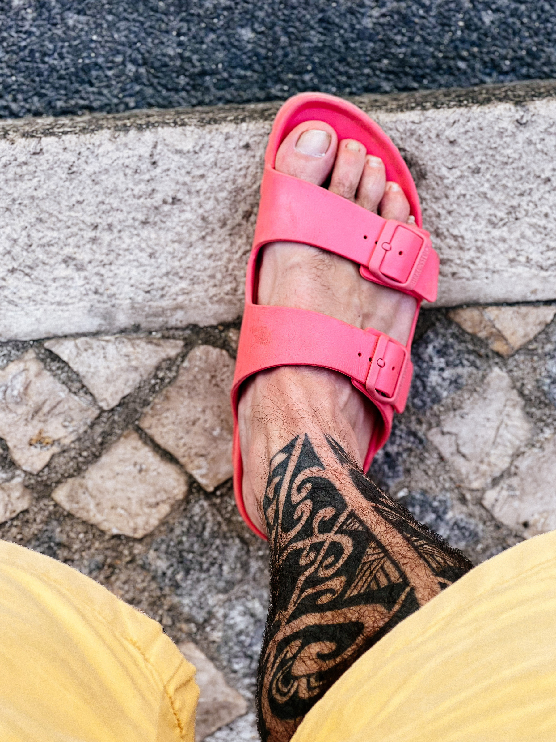 A foot with a pink Birkenstock sandal 