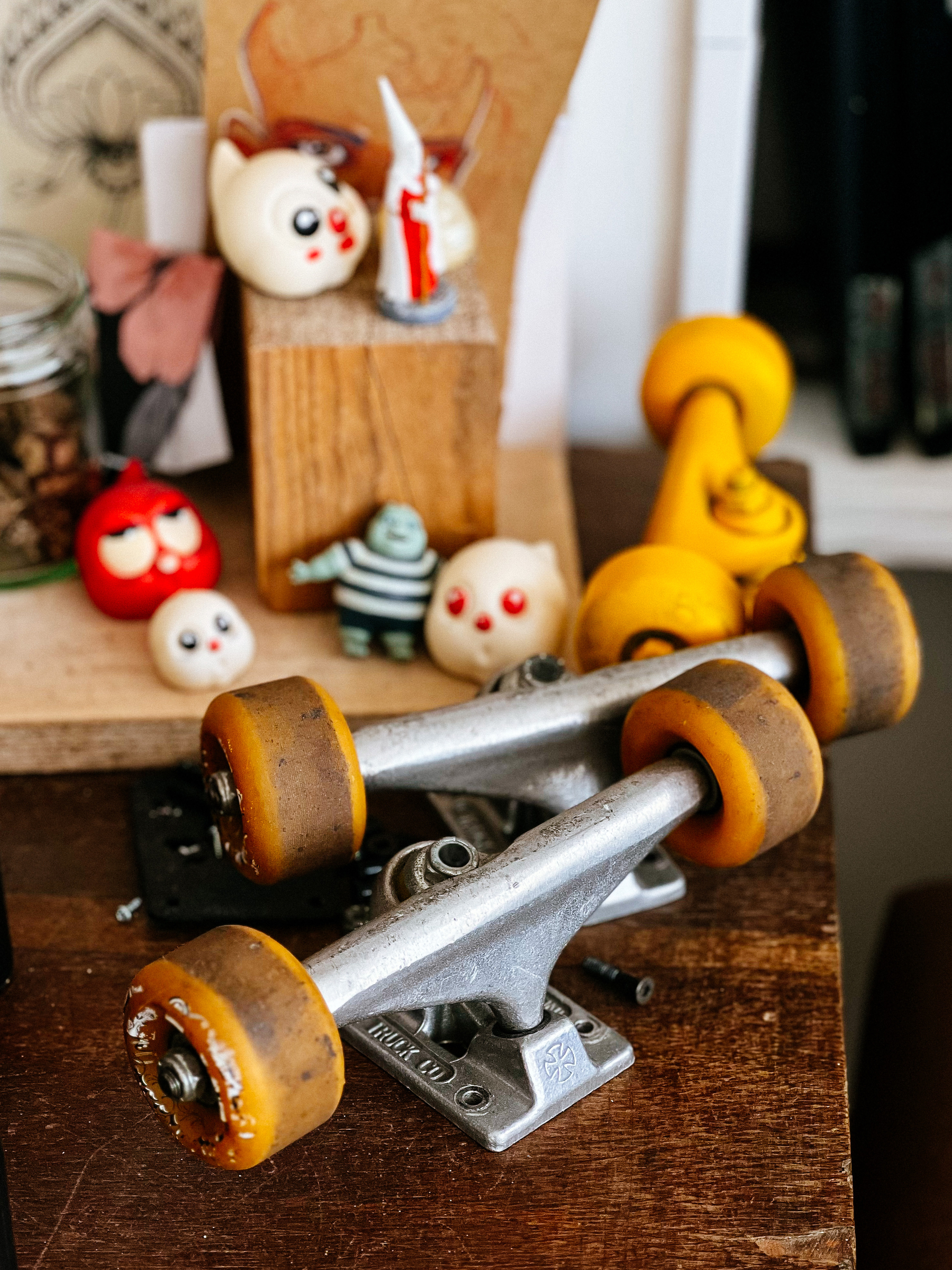 Skate parts and other assorted toys on a desk. 