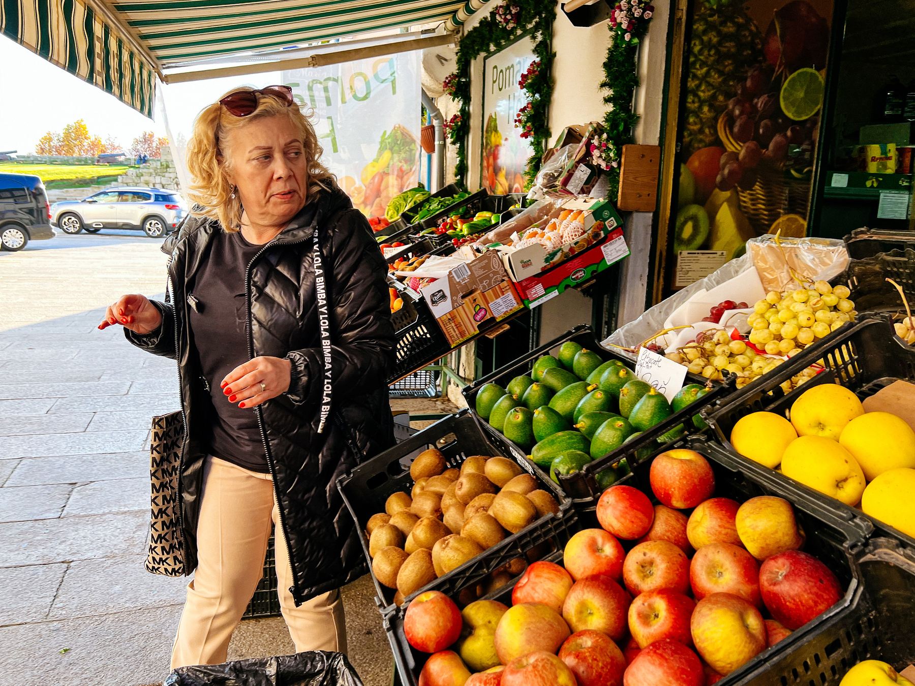 A women looks at a fruit stall. 