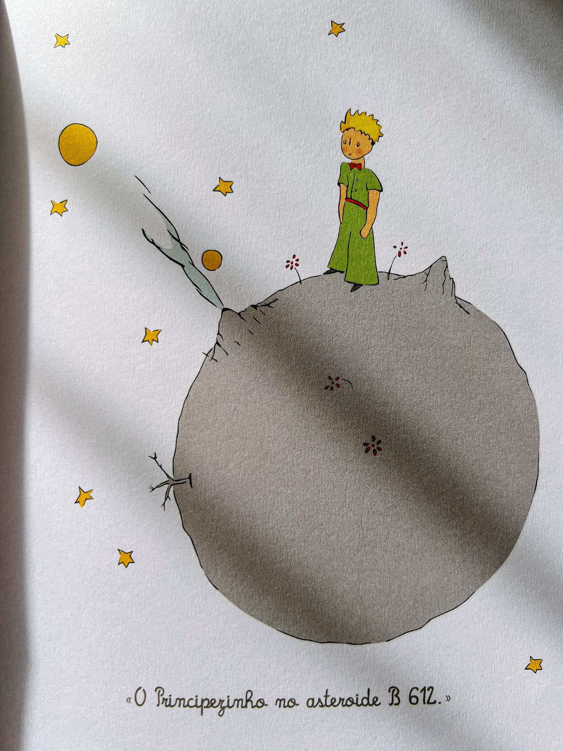 A book page, with an illustration of the Little Prince, on asteroid B 612. 