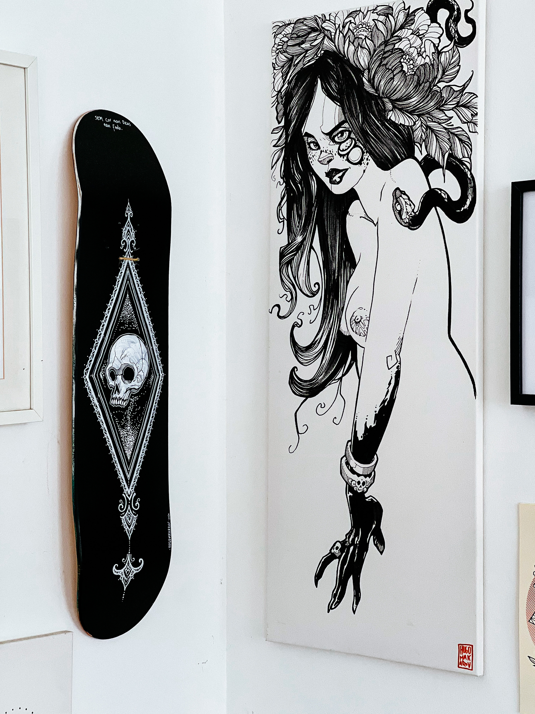A skateboard and an illustration of a woman, on a wall. 