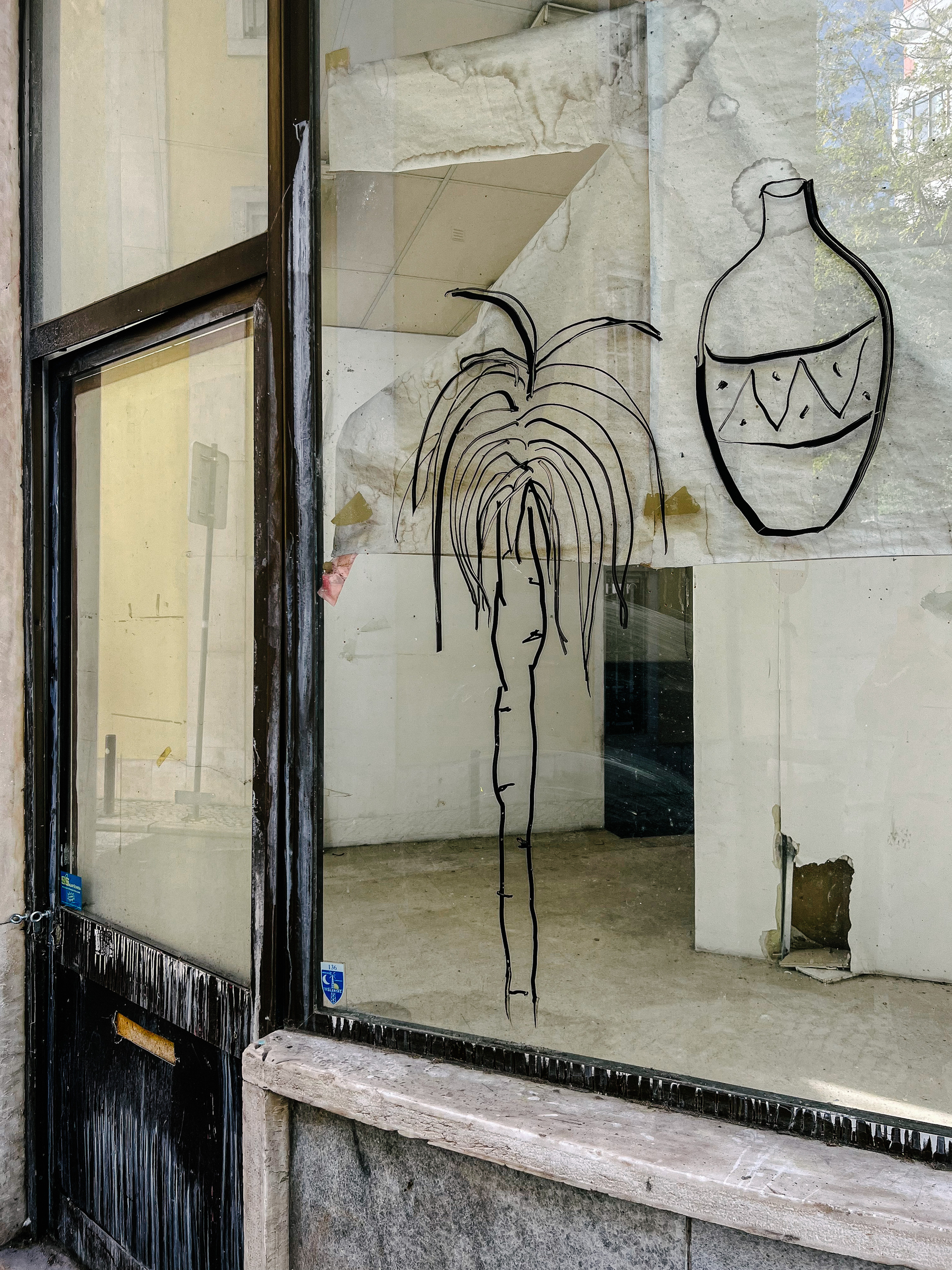 a palm tree is hand drawn on a closed shop window
